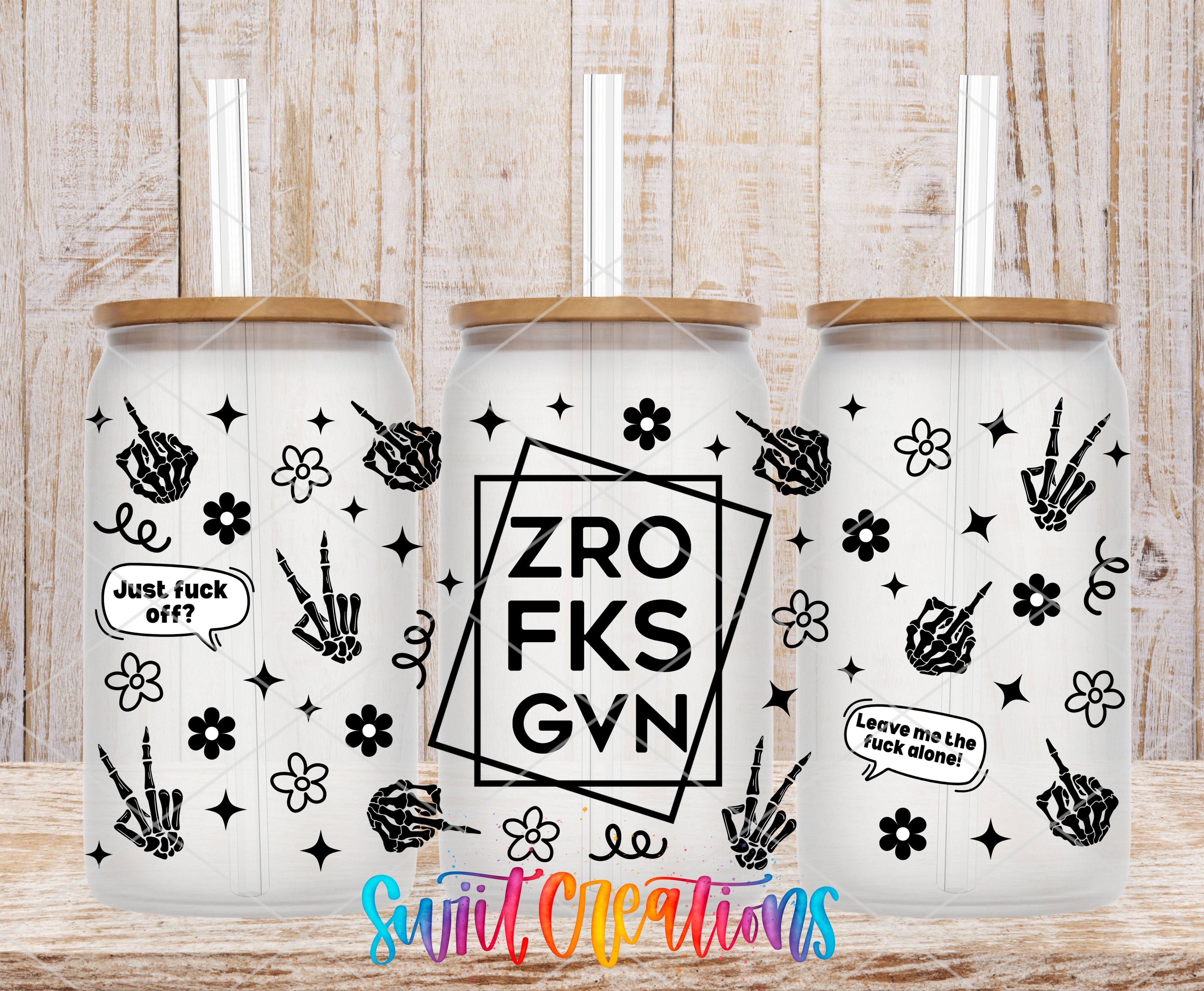three white tumblers with black designs and text on them, placed on a wooden surface.