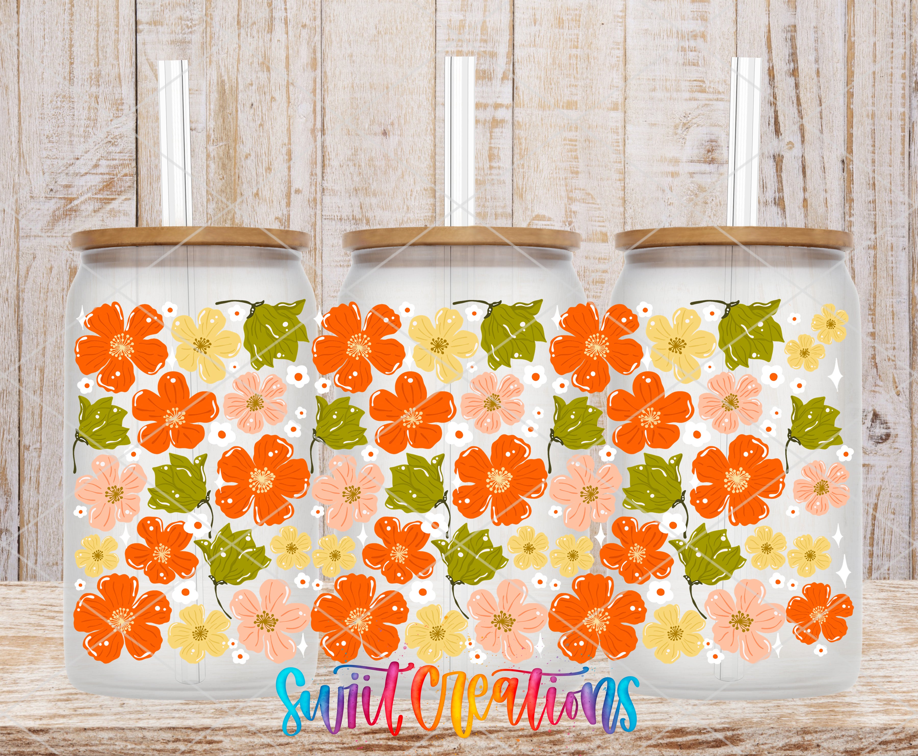 Three glass jars with floral designs on them, placed on a wooden surface.