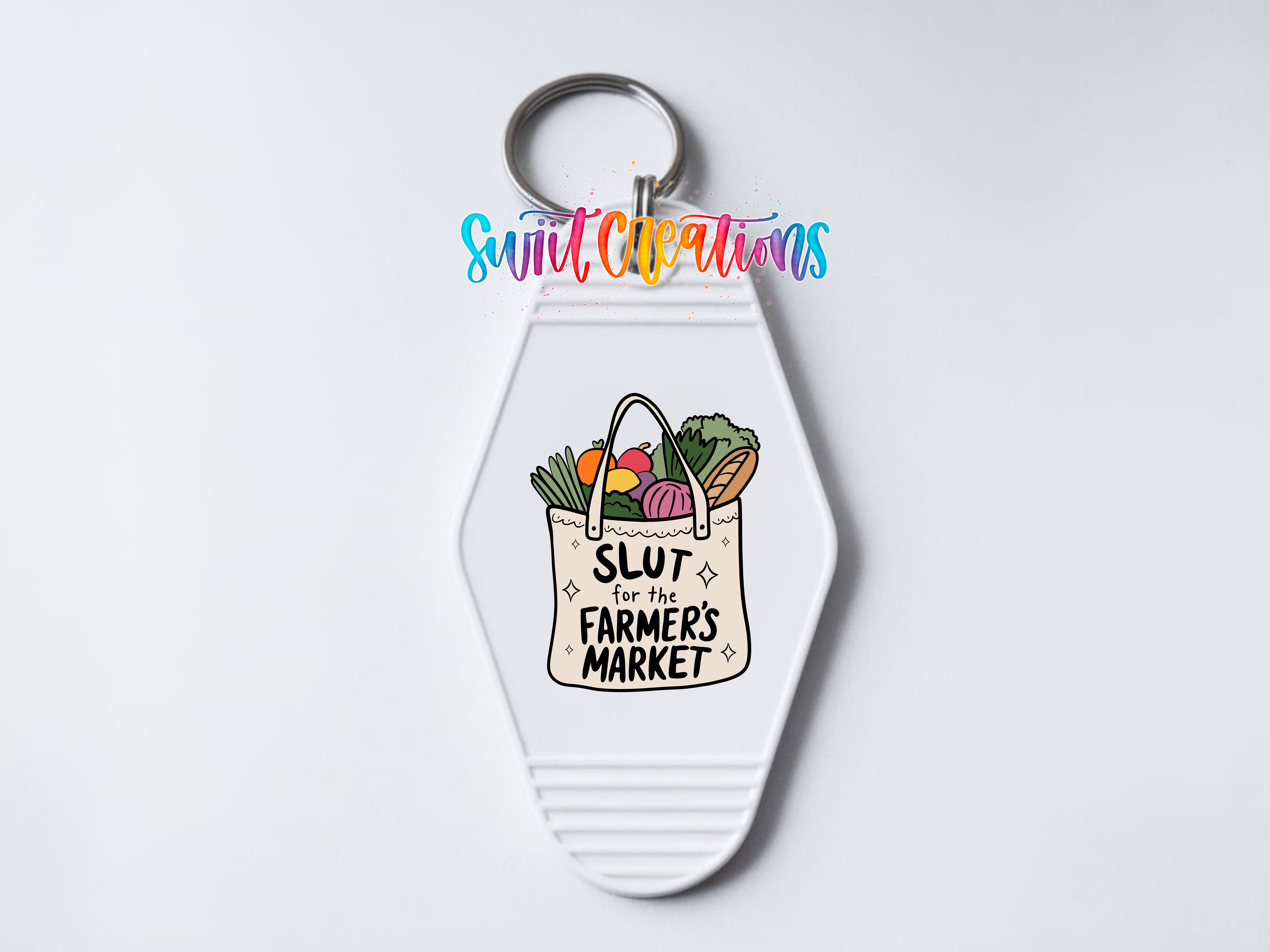 A keychain with a white bag containing various fruits and vegetables, along with the text "SLUT for the FARMERS MARKET" printed on it.