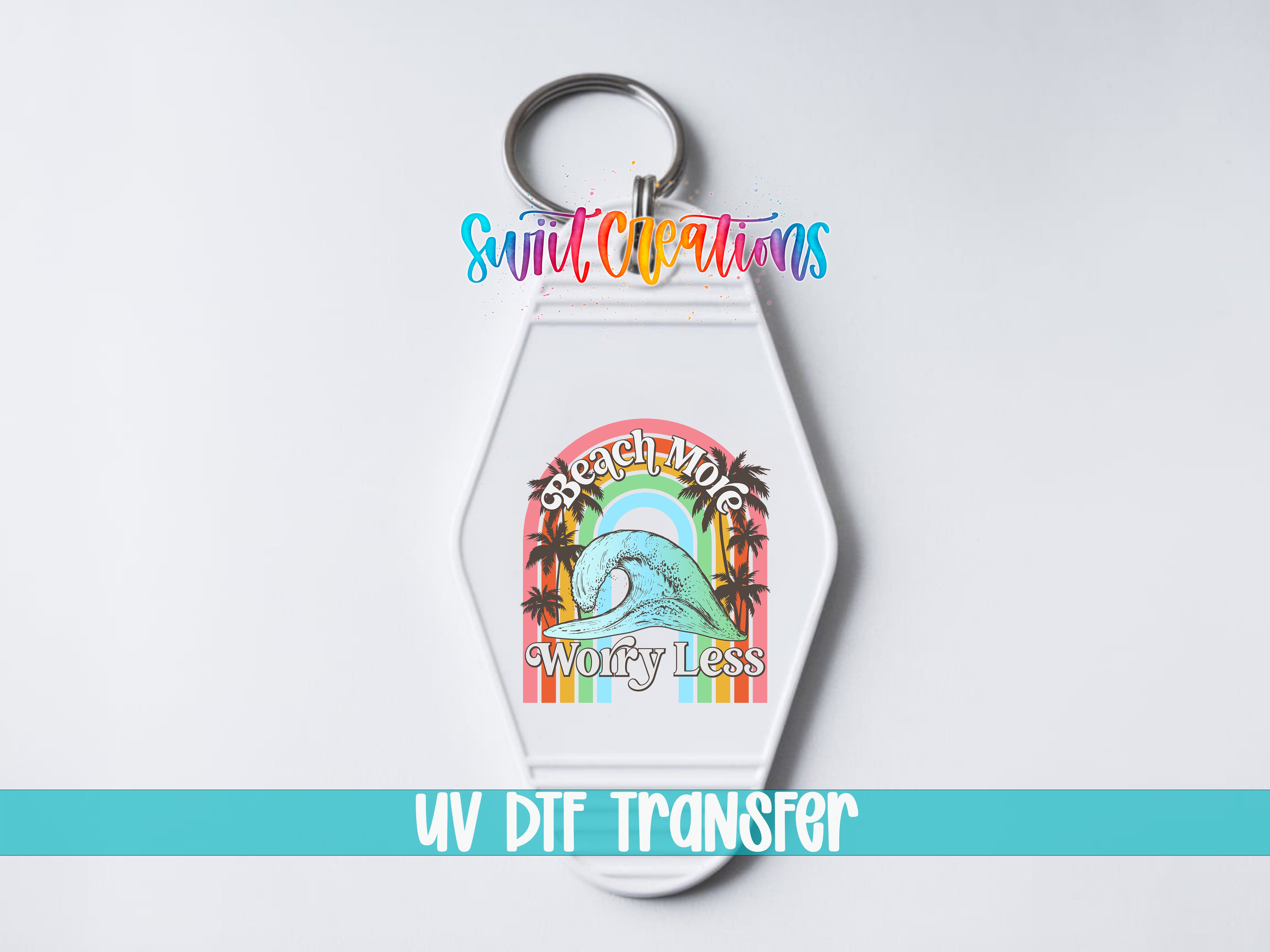 A keychain with a colorful graphic design and text, including a rainbow and the phrase "Worry Less".