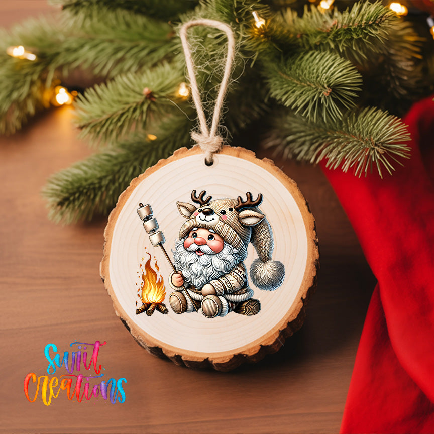 A wooden ornament featuring a cartoon image of a reindeer holding a campfire, with a Santa Claus-like figure wearing a hat and scarf. The ornament is hanging on a Christmas tree, and there is a red cloth visible in the background.