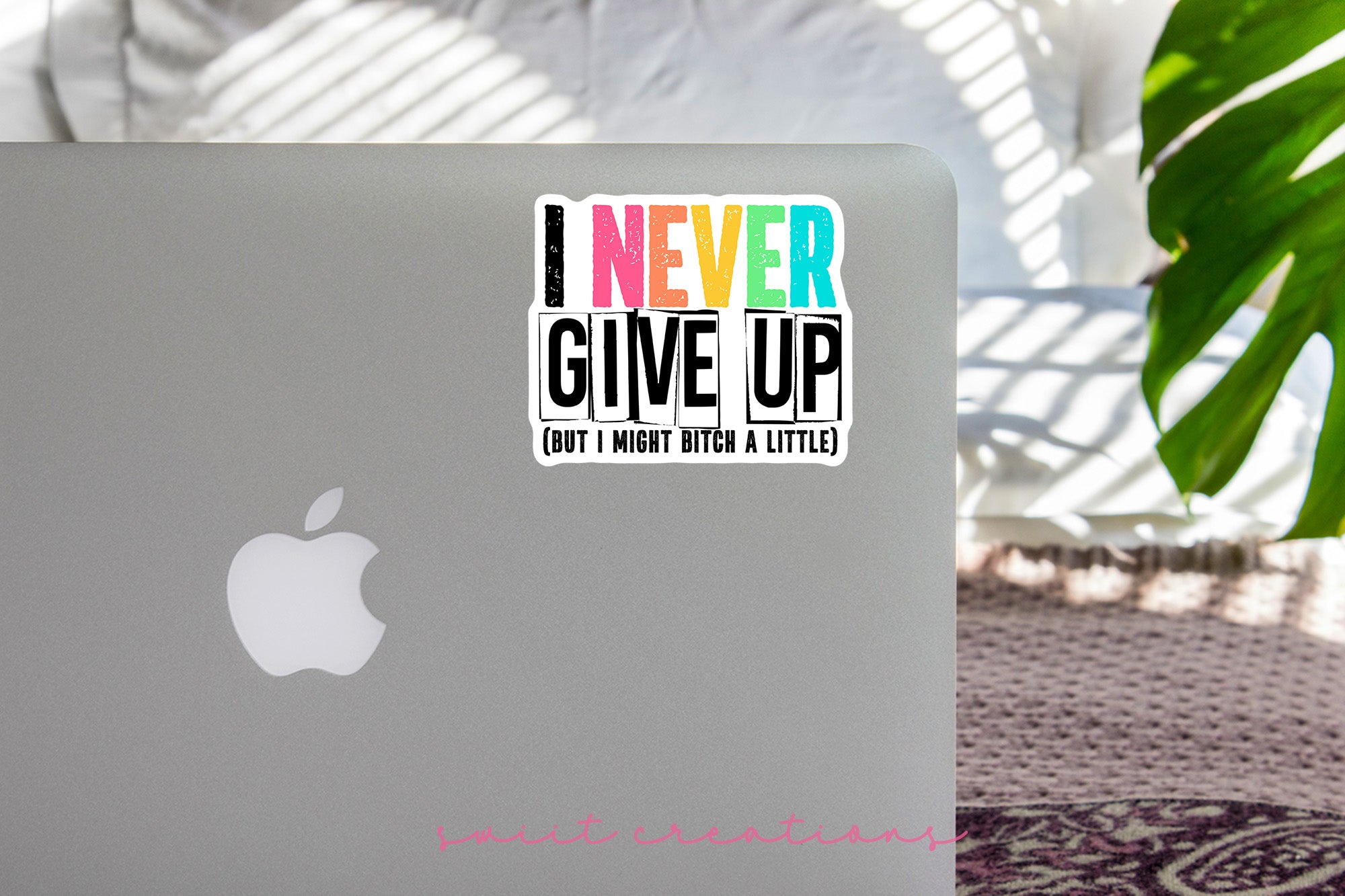 a laptop with a sticker that says i never give up