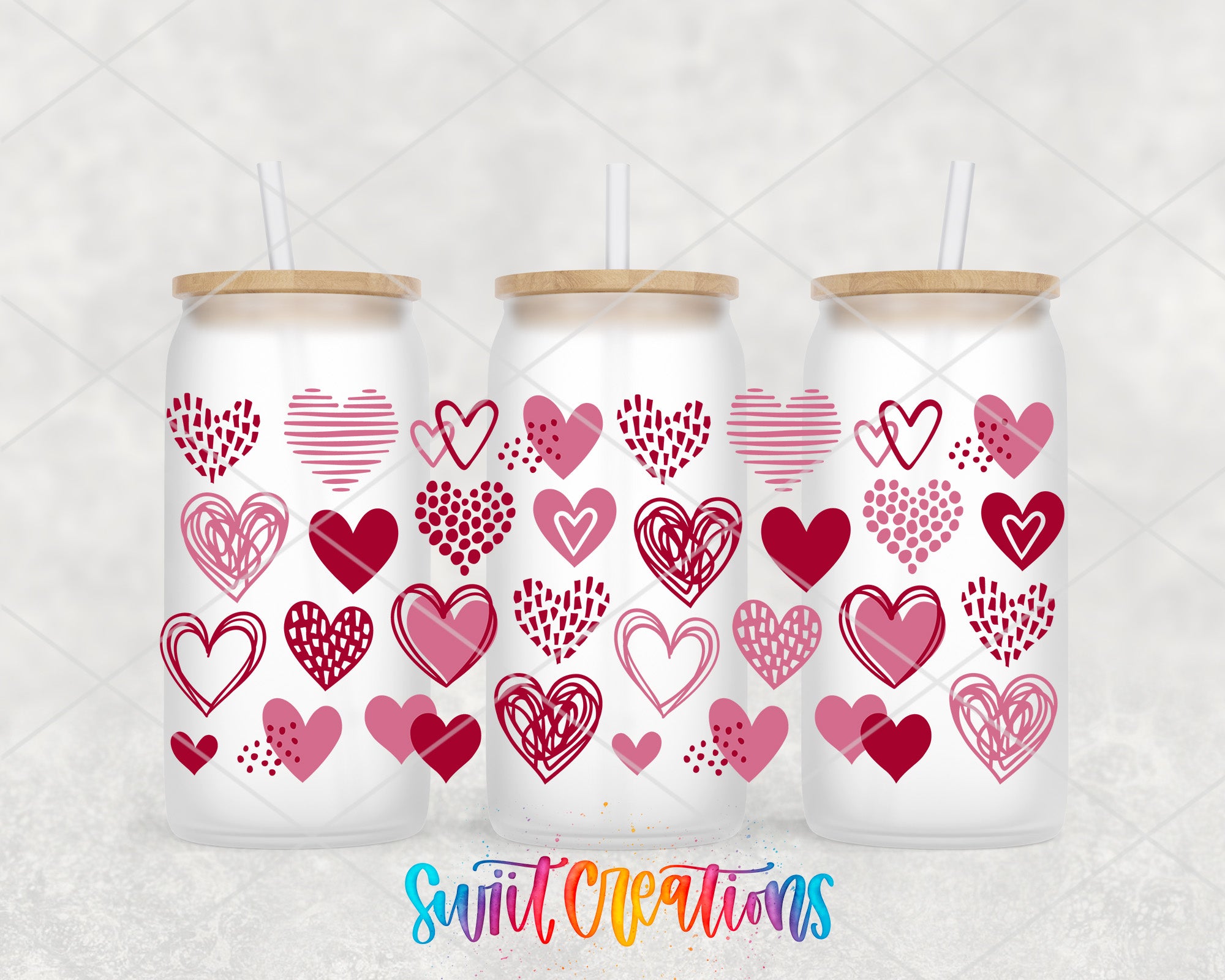 Three glass tumblers with heart designs on them, arranged in a row.
