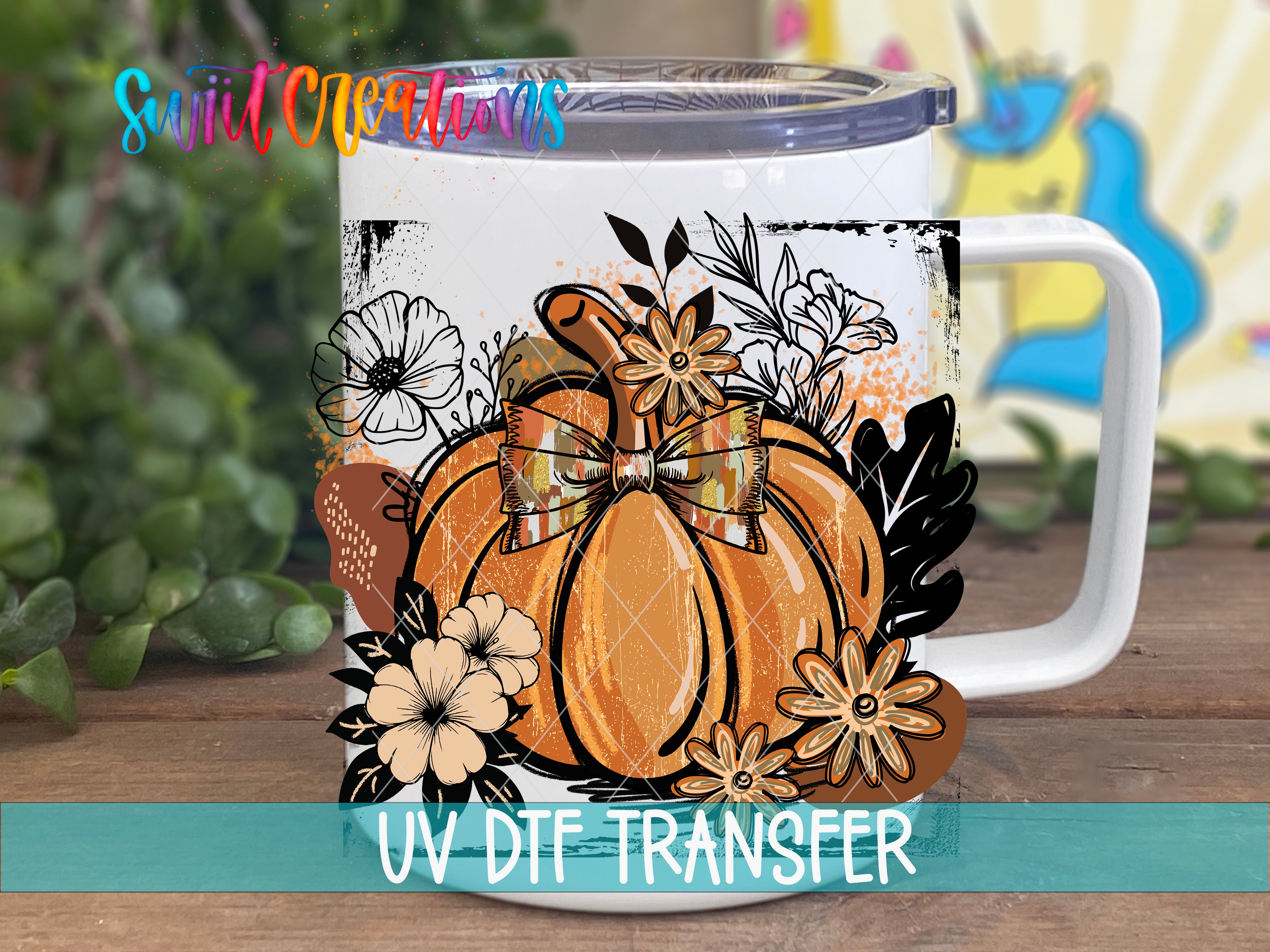 A white mug with a pumpkin and floral design printed on it, placed on a wooden surface.