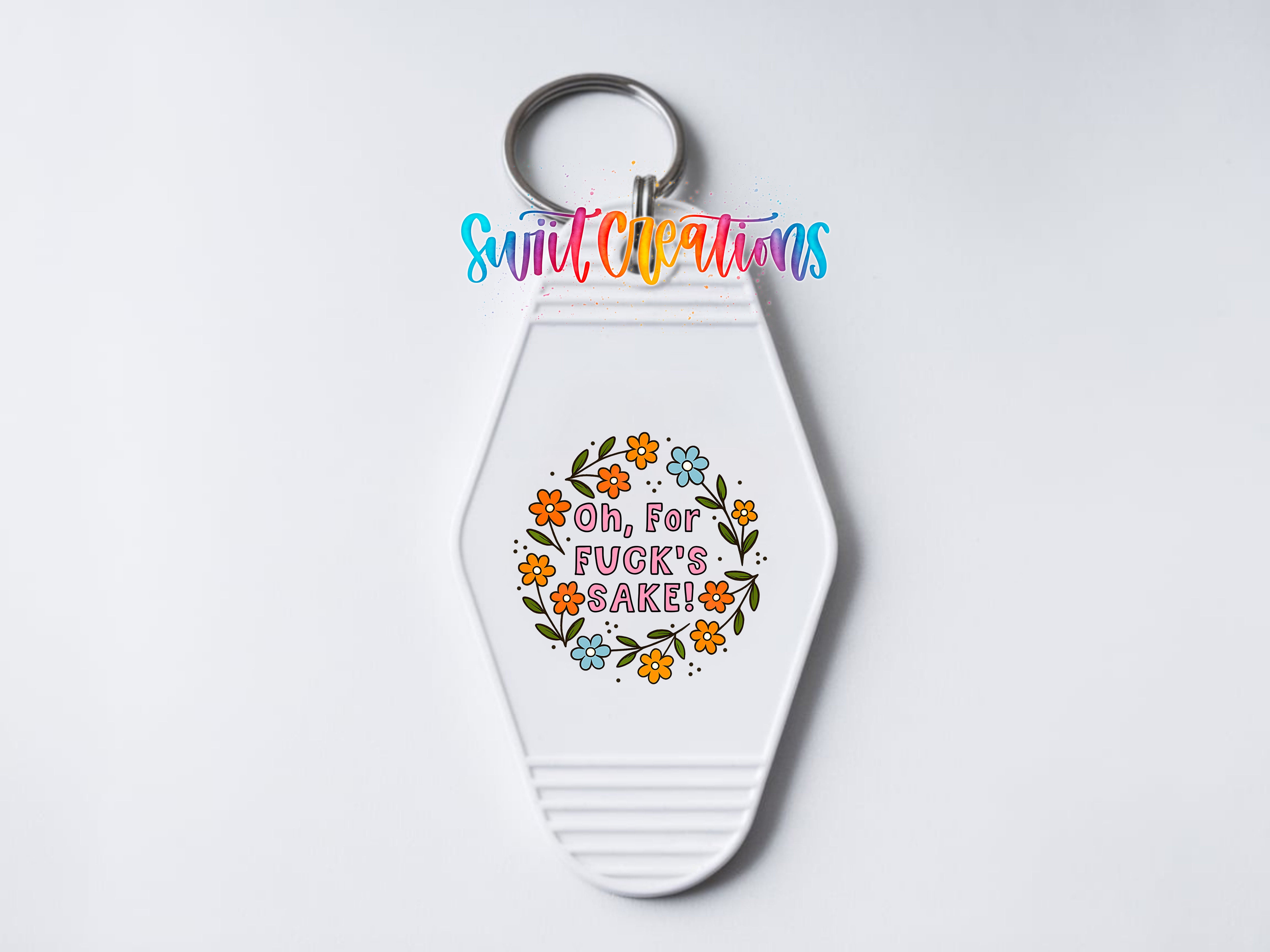 A white keychain with a colorful design and text on it.