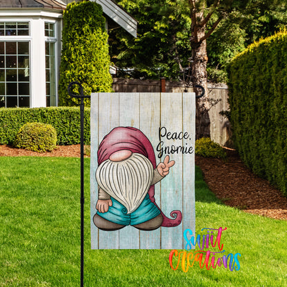 A wooden garden sign featuring a gnome holding a peace sign, with the text "Peace, Gnome" written on it.