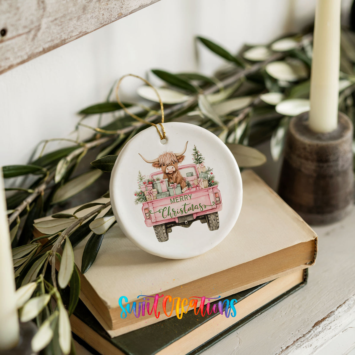 A ceramic ornament featuring a cow with horns, sitting in a pink truck, is displayed on top of a stack of books.