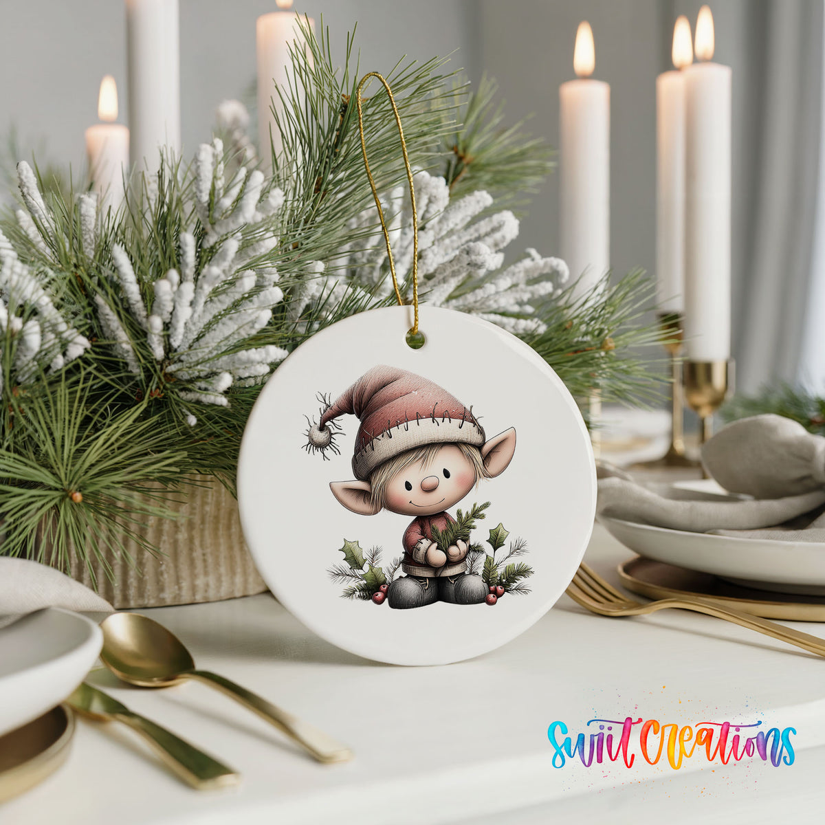 A white ornament featuring a cartoon elf wearing a Santa hat and holding a Christmas tree is displayed on a table with candles and greenery in the background.