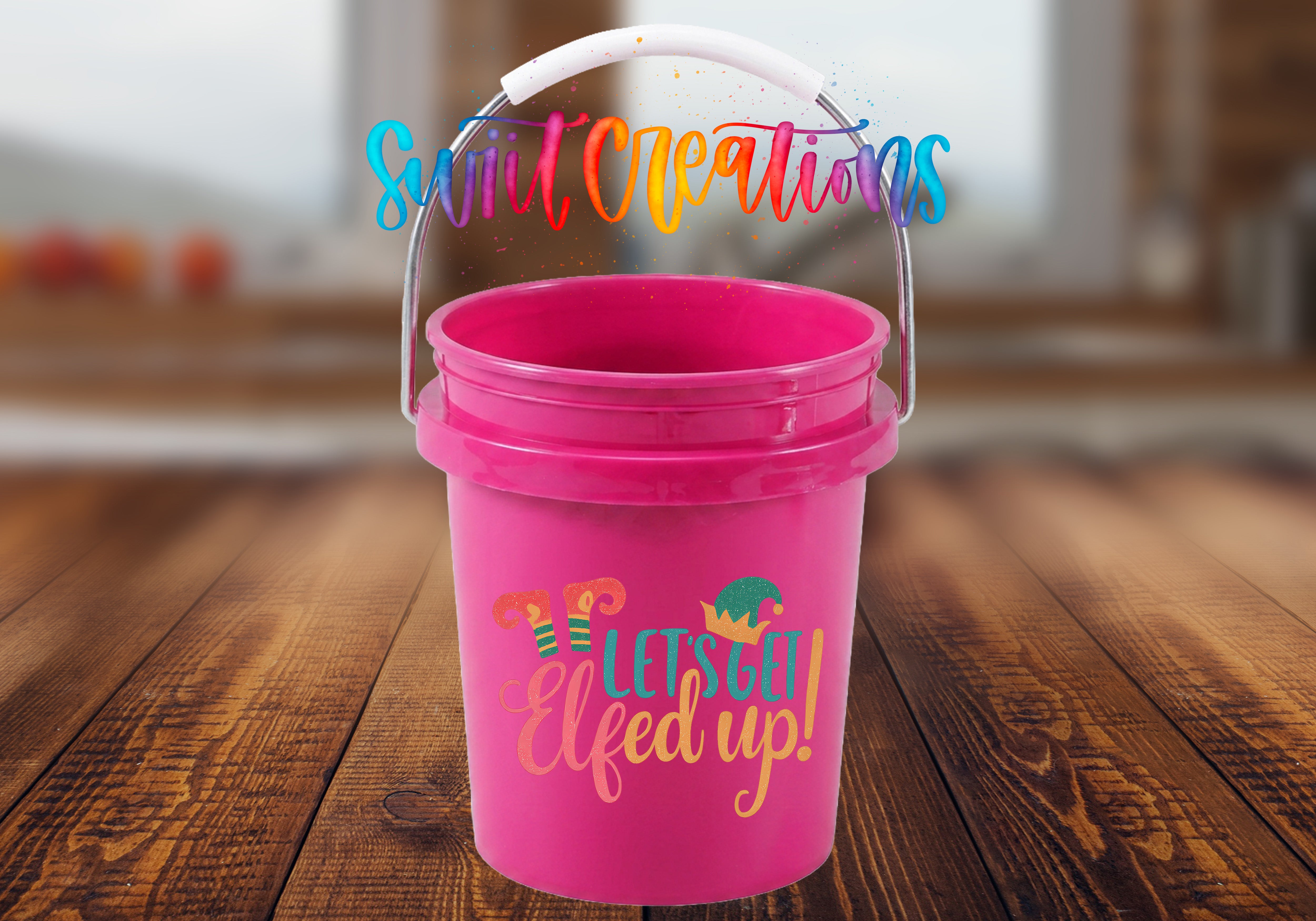 A pink bucket with a handle and a colorful, whimsical text that says "Let's get Elfed up!"