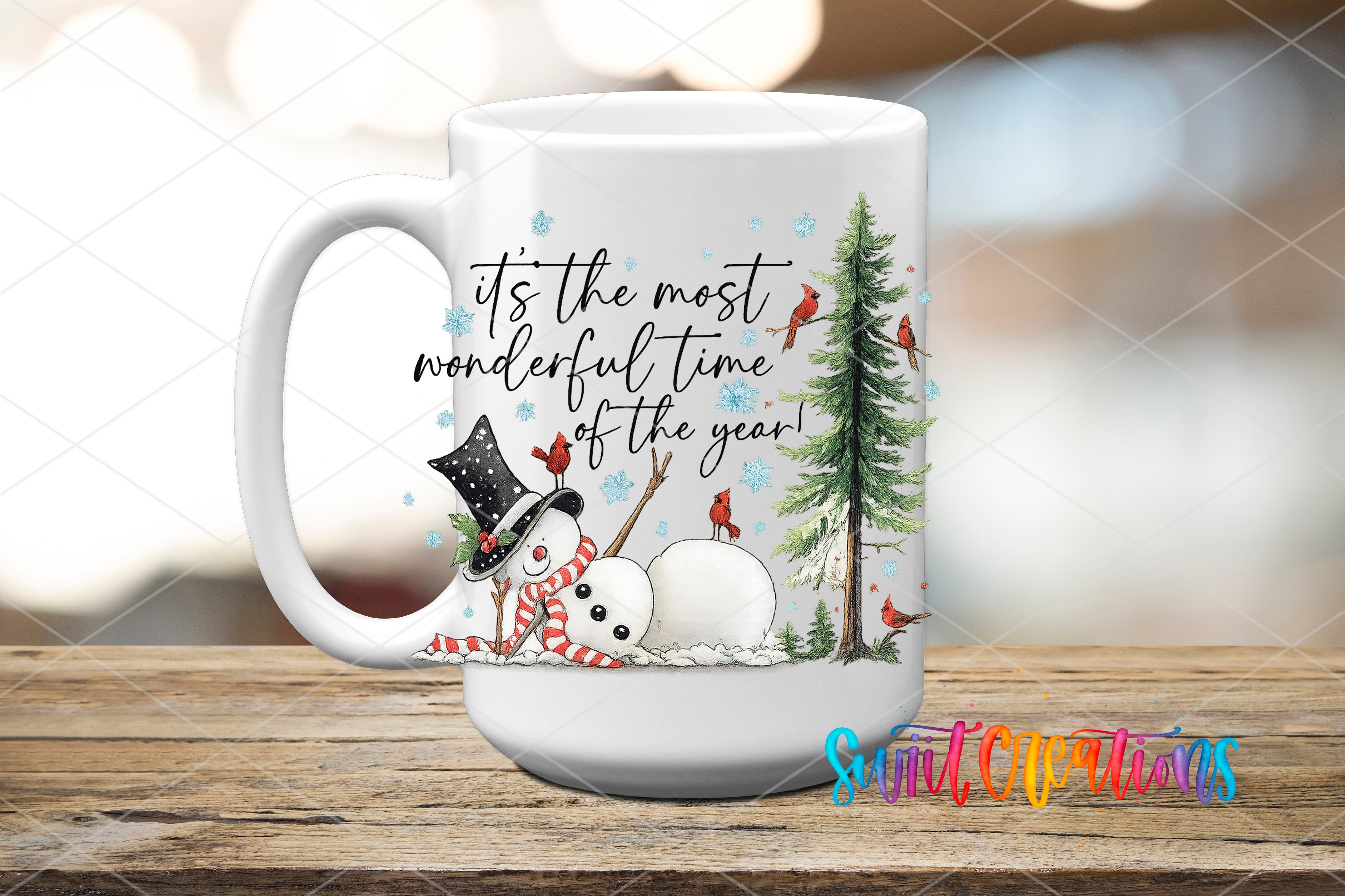 A white mug with a winter-themed design featuring a snowman, a snowman with a carrot nose, and a pine tree. The mug also has a message that reads "It's the most wonderful time of the year!"