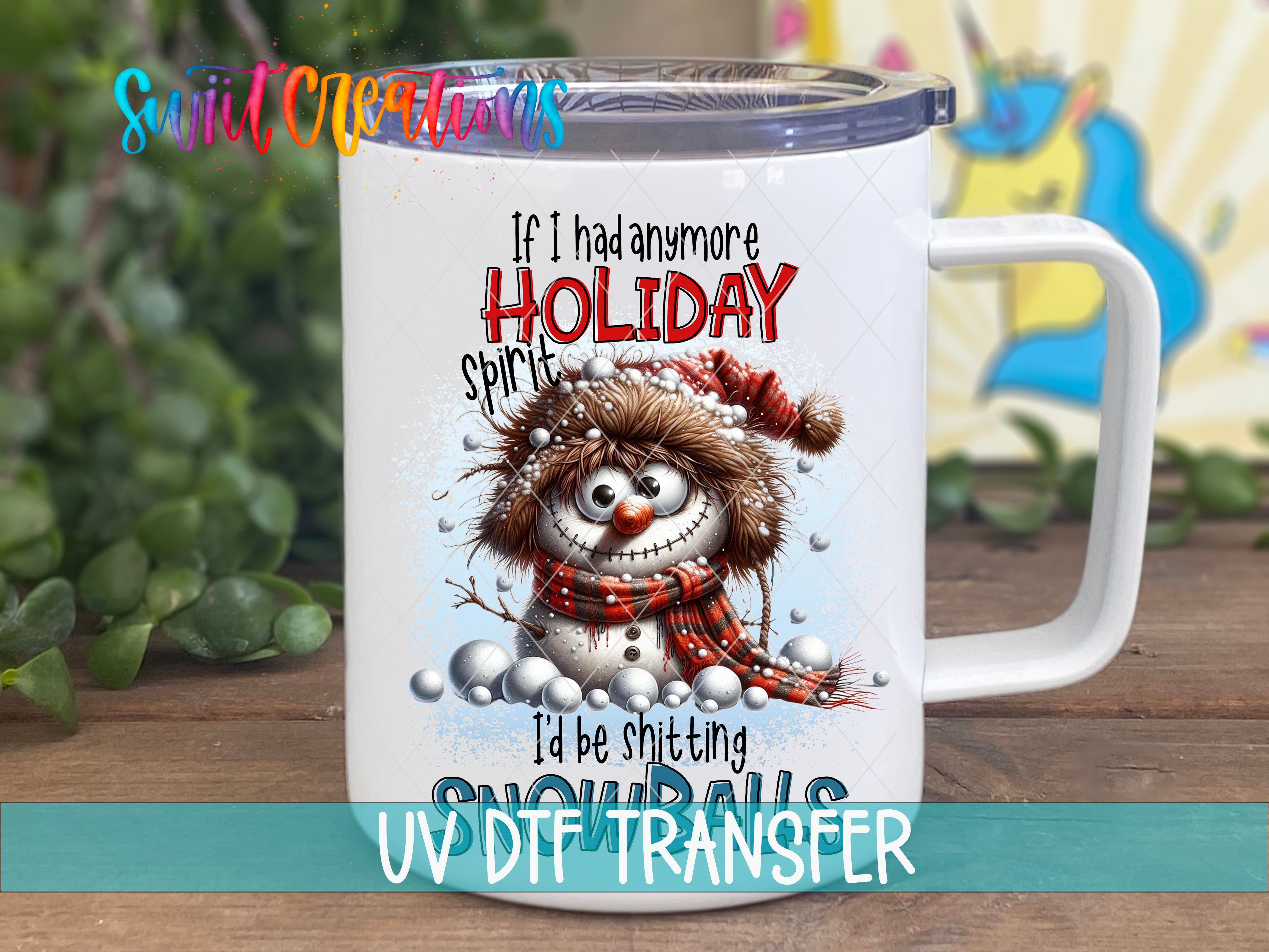 A white mug with a snowman design and text printed on it, placed on a wooden surface.