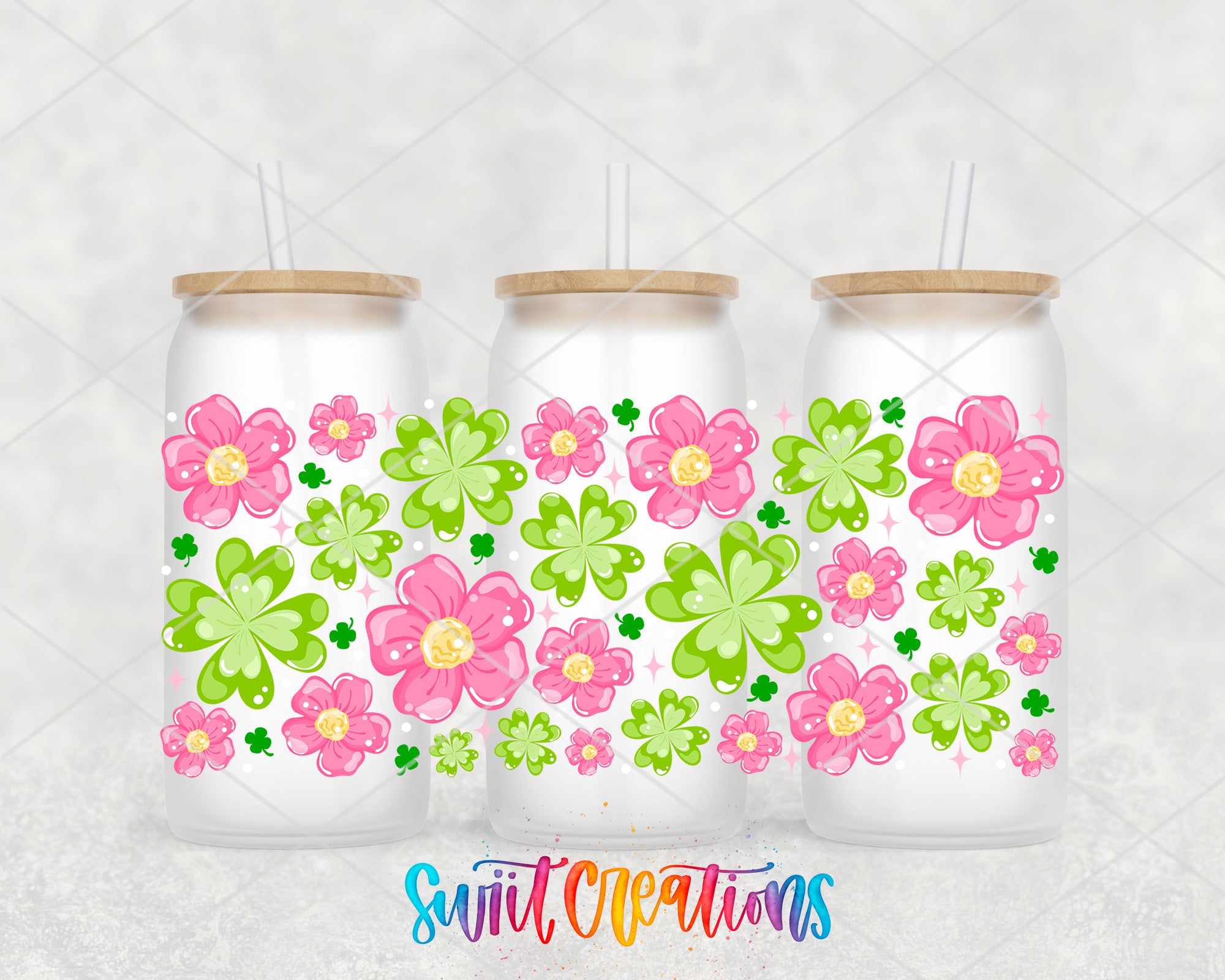 three glass tumblers with pink and green flowers on them, each with a straw.