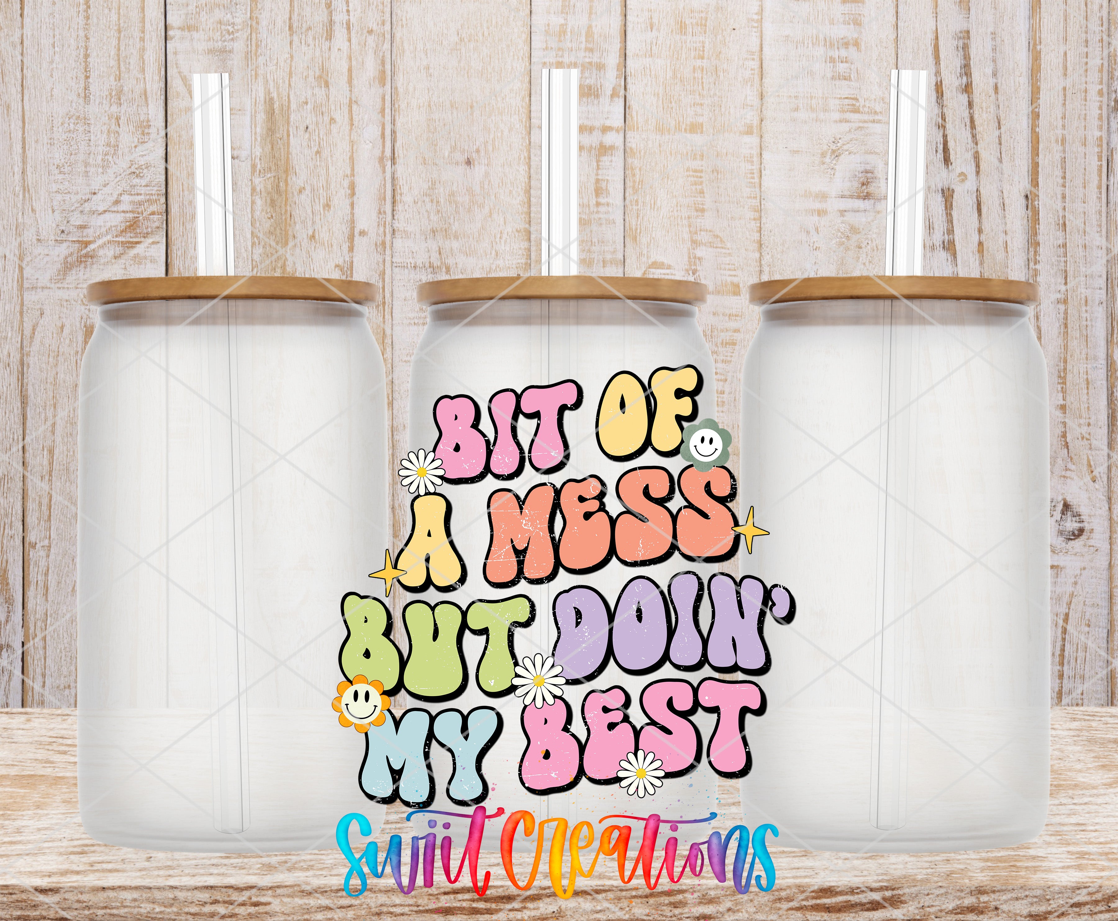 three clear glass jars with lids, arranged in a row against a wooden background. The jars have straws sticking out of them. The text in the center of the image says "BIT OF A MESS BUT DOIN' MY BEST" in a colorful, stylized font.