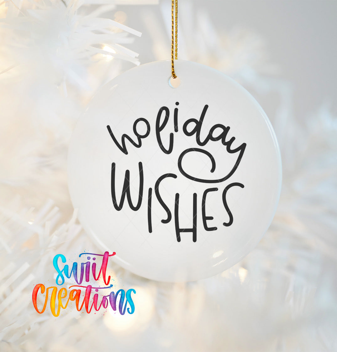A white ornament with the text "Holiday Wishes" written on it, hanging on a Christmas tree.