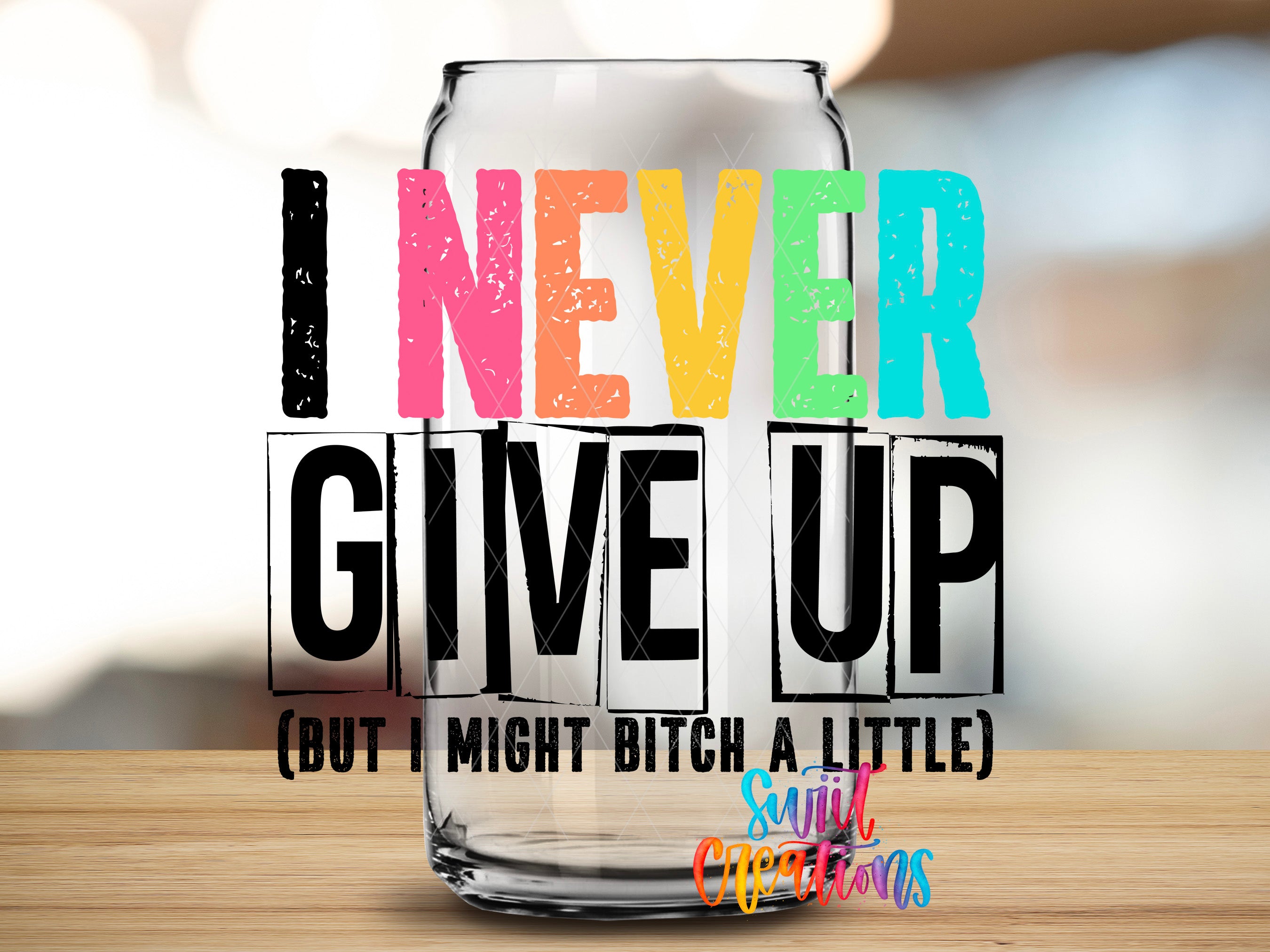 a colorful text overlay on a glass jar, which reads "I NEVER GIVE UP (BUT I MIGHT BITCH A LITTLE)" along with a smaller text that says "Suitcase Creations".