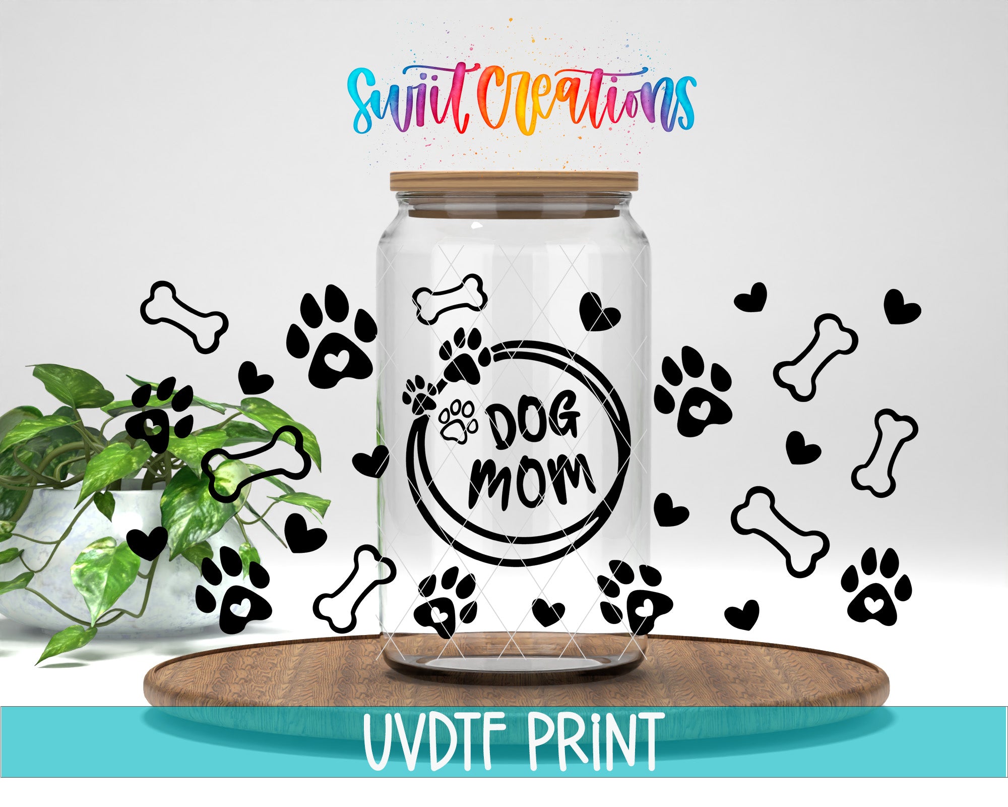 A glass jar with a lid, decorated with black paw prints and the text "Dog mom" inside, surrounded by additional paw prints and hearts. The jar is placed on a wooden surface, and there is a plant in the background.