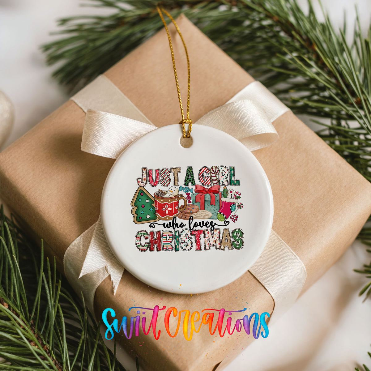 A white ceramic ornament with a ribbon and a Christmas tree branch, featuring a colorful design with text and illustrations.