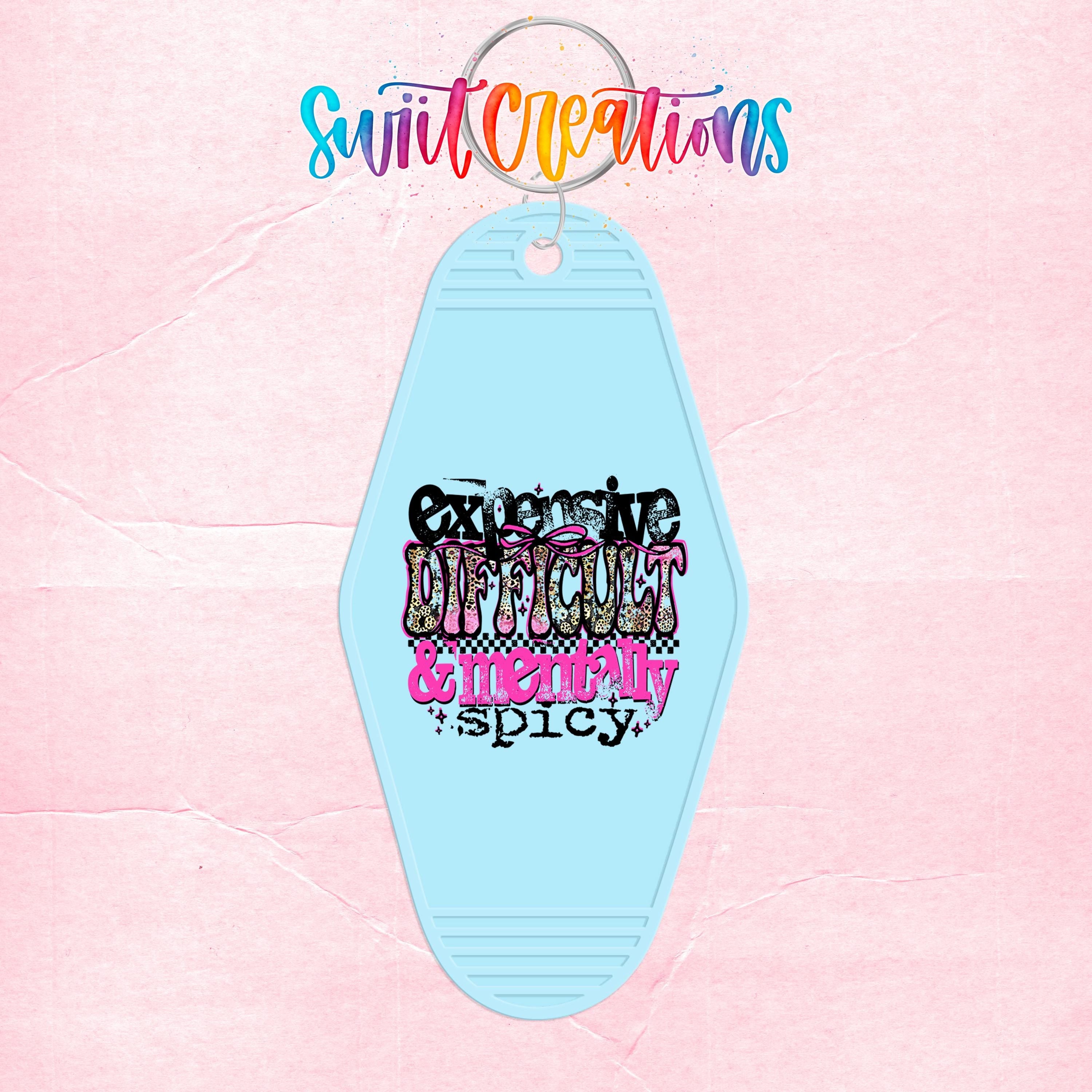 A keychain with a light blue color and a colorful, stylized text design on it.
