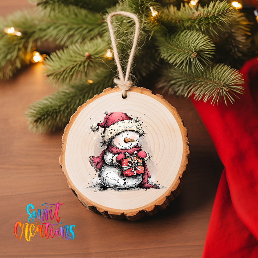 A wooden ornament featuring a snowman is hanging on a Christmas tree, with a red cloth visible in the background.