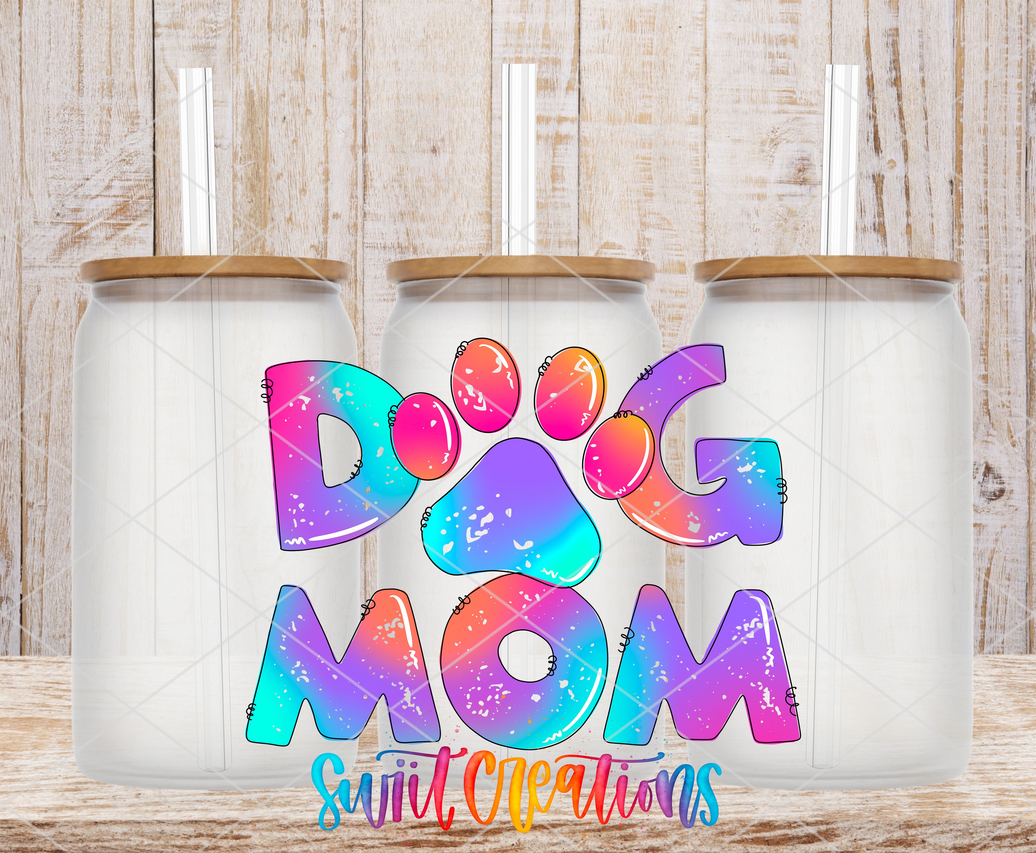 three glass jars with lids, each containing a straw, and the text "DOG MOM" written in a colorful, rainbow-like font.