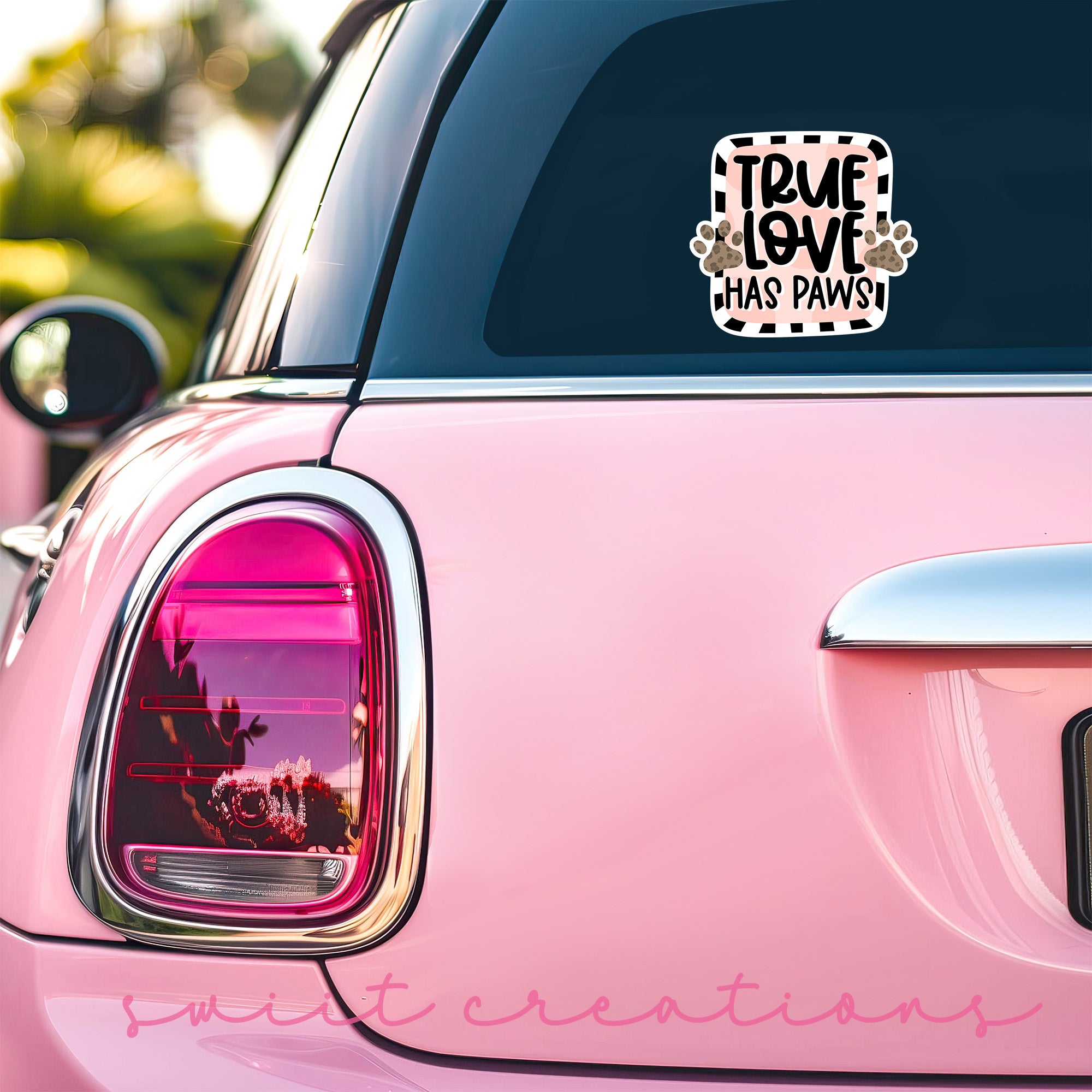 a pink car with a sticker on the back of it