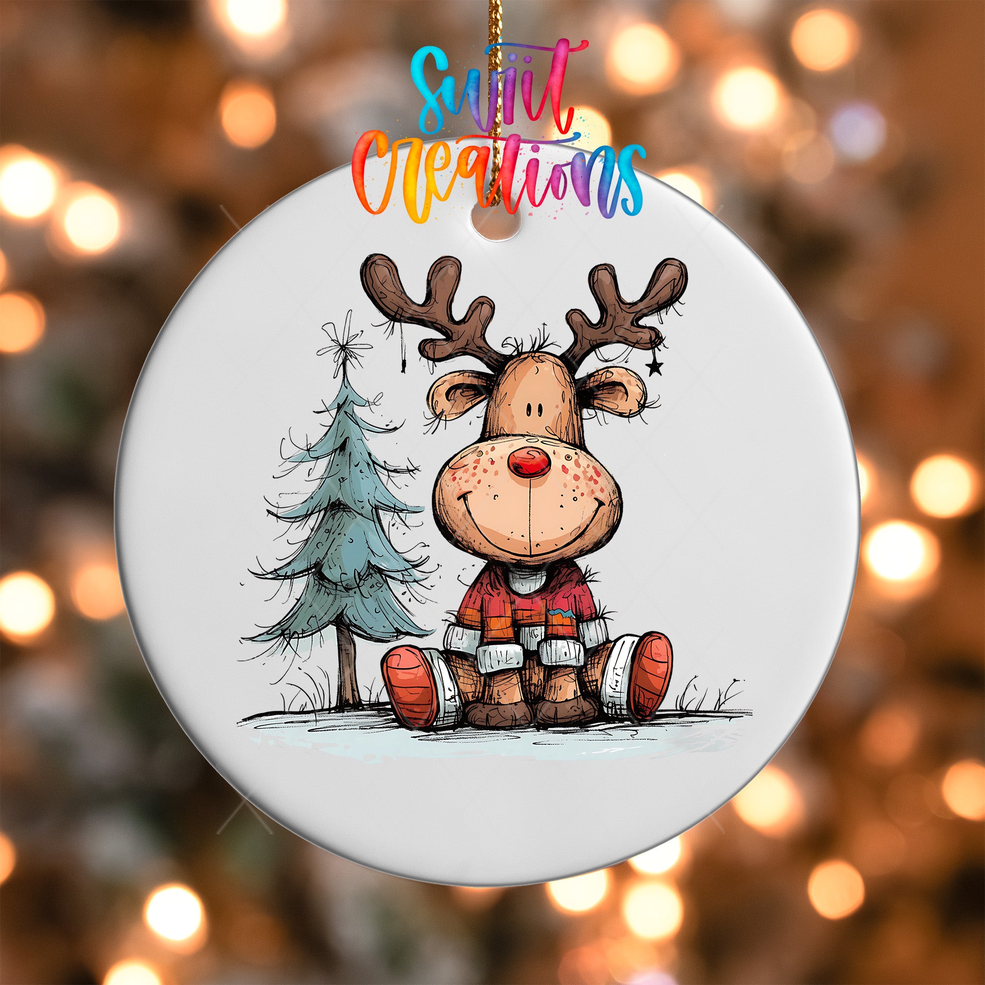 A white ornament featuring a cartoon reindeer sitting next to a Christmas tree.
