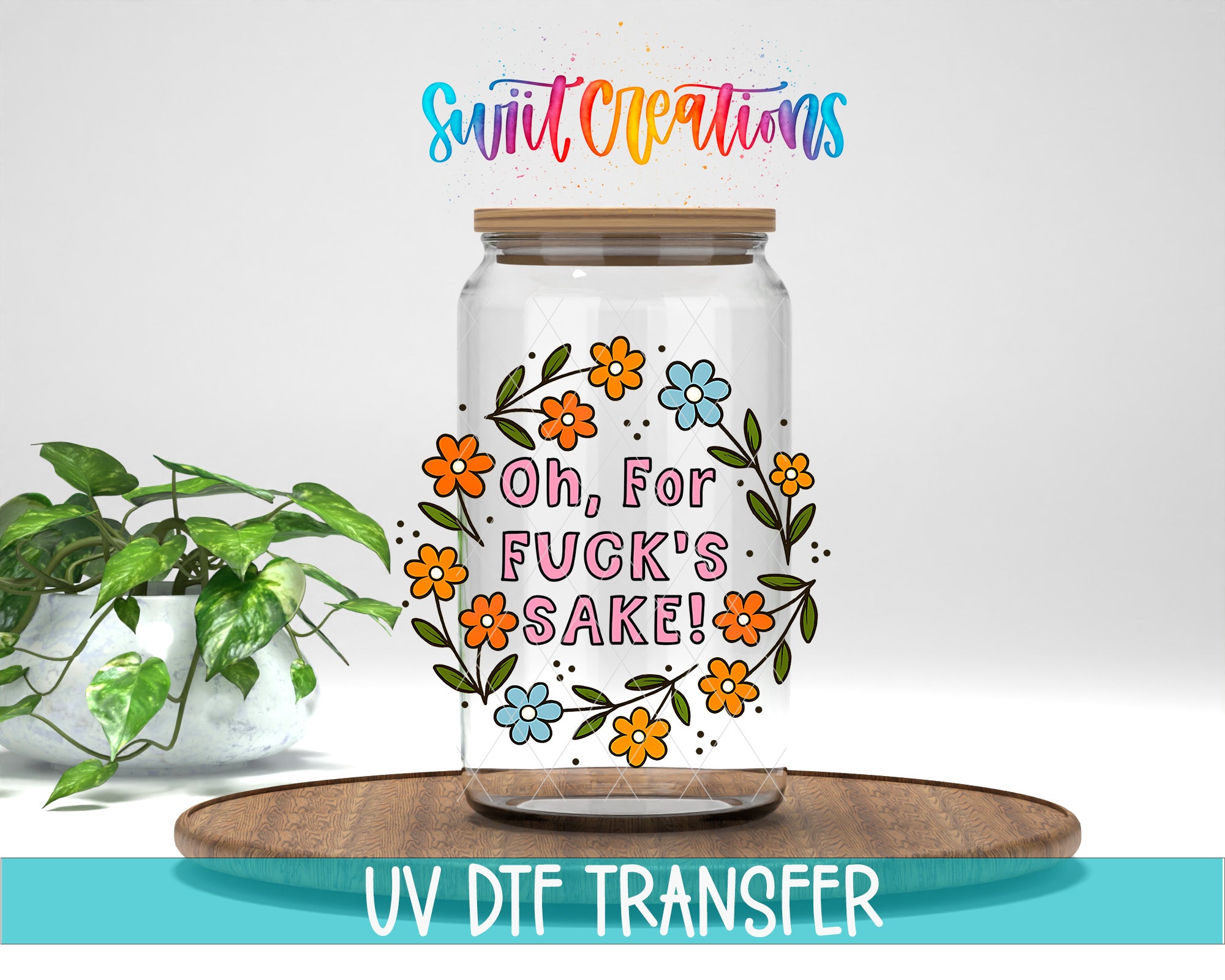 a clear glass jar with a floral design and text on it, placed on a wooden surface.