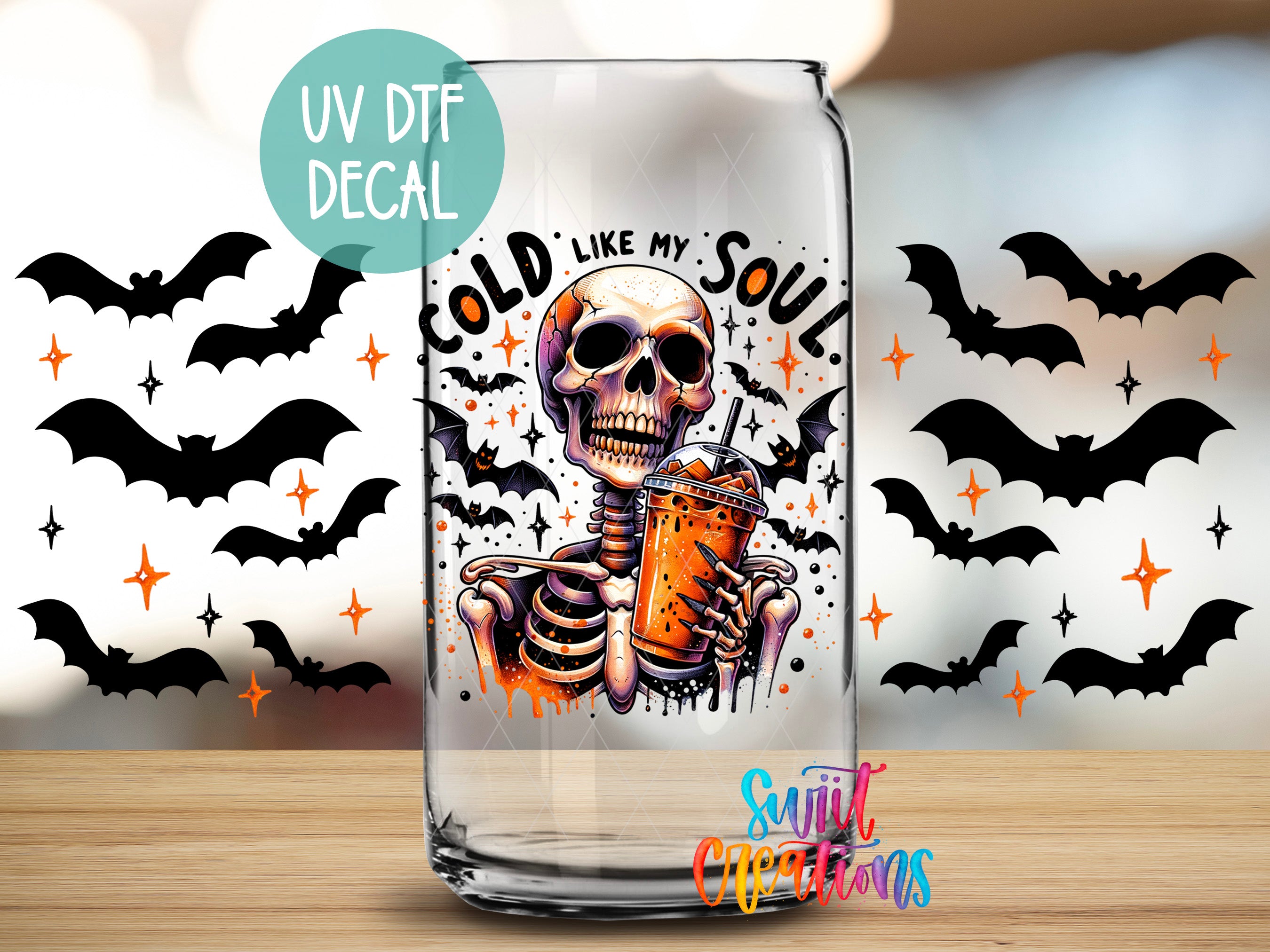A glass with a skeleton holding a drink, surrounded by bats and stars, with a UV decal that says "COLD LIKE MY SOUL" and "Sunlit Creations" written below.