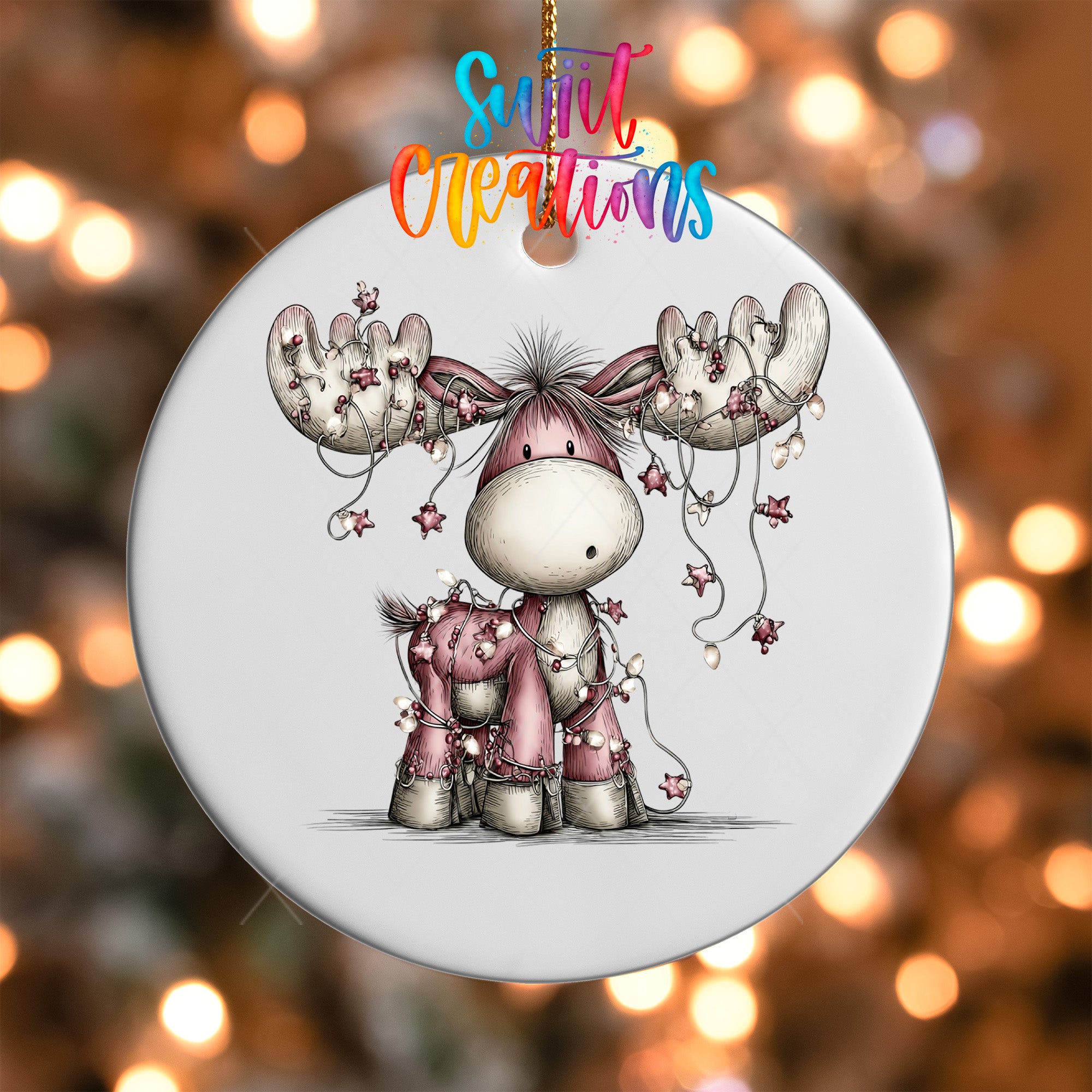 A white ornament with a cartoon moose and Christmas lights.