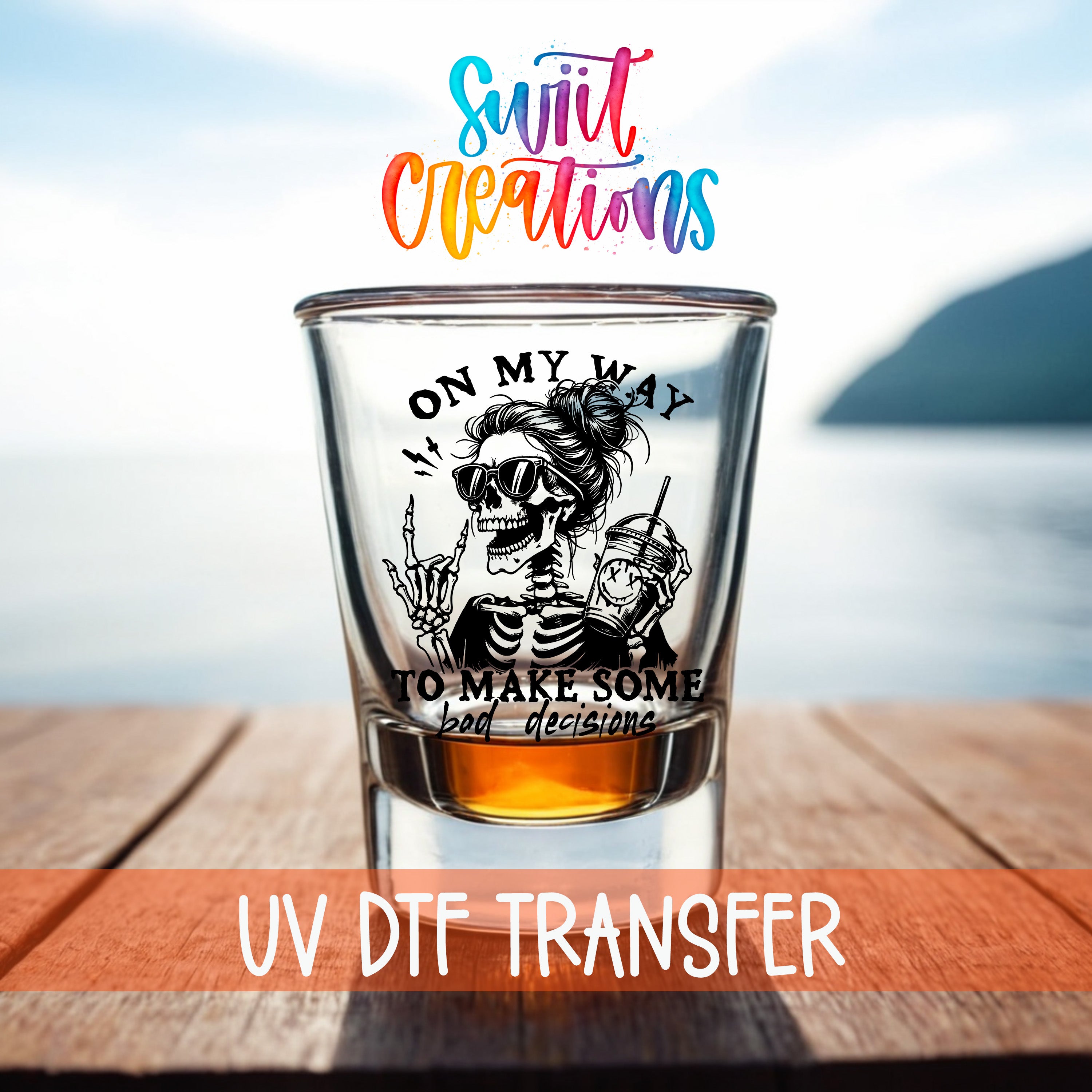 A shot glass with a skeleton wearing sunglasses and holding a drink, set against a blurred background of a body of water and a mountain.