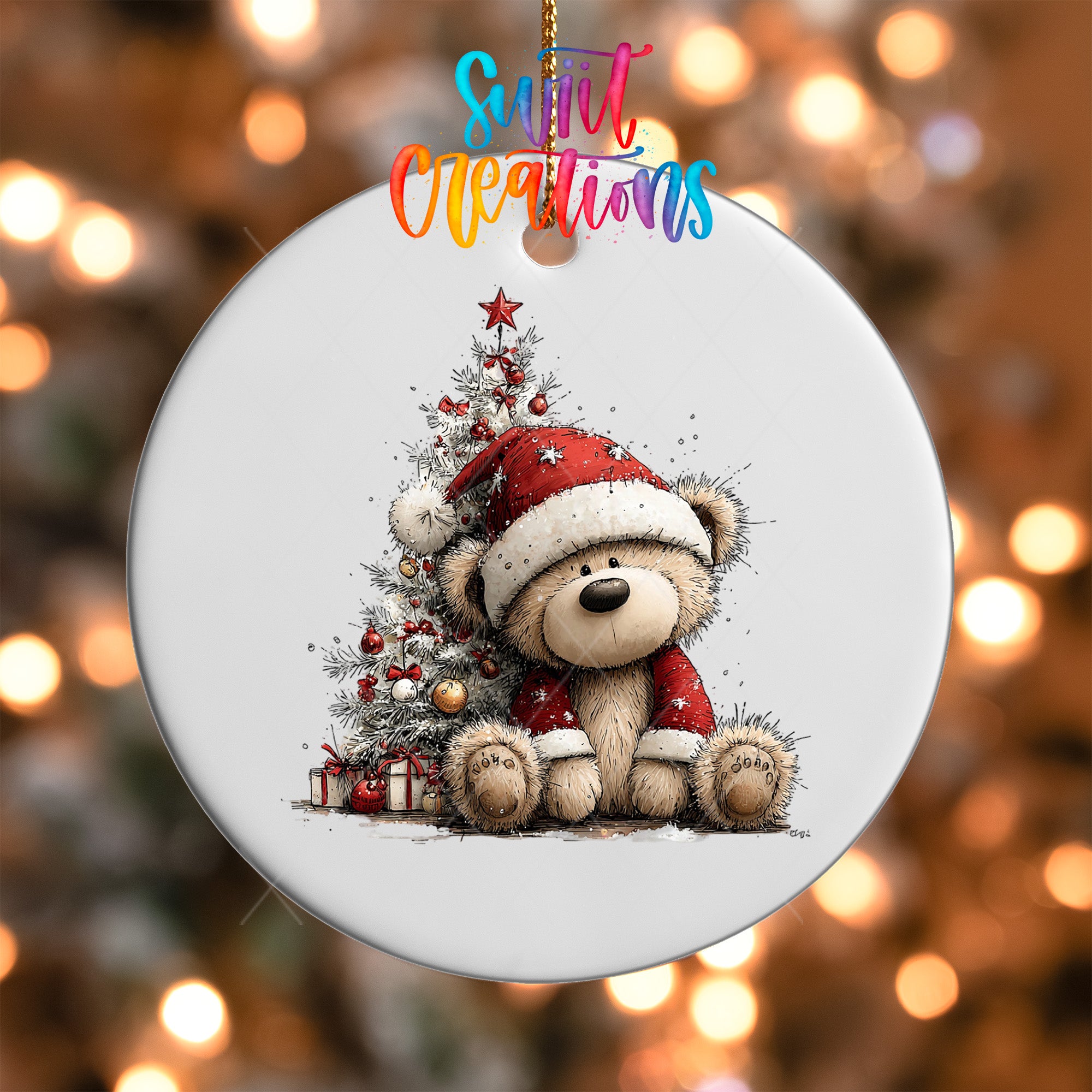 A white ornament with a teddy bear wearing a Santa hat and a red Santa sweater, sitting next to a Christmas tree with presents underneath.