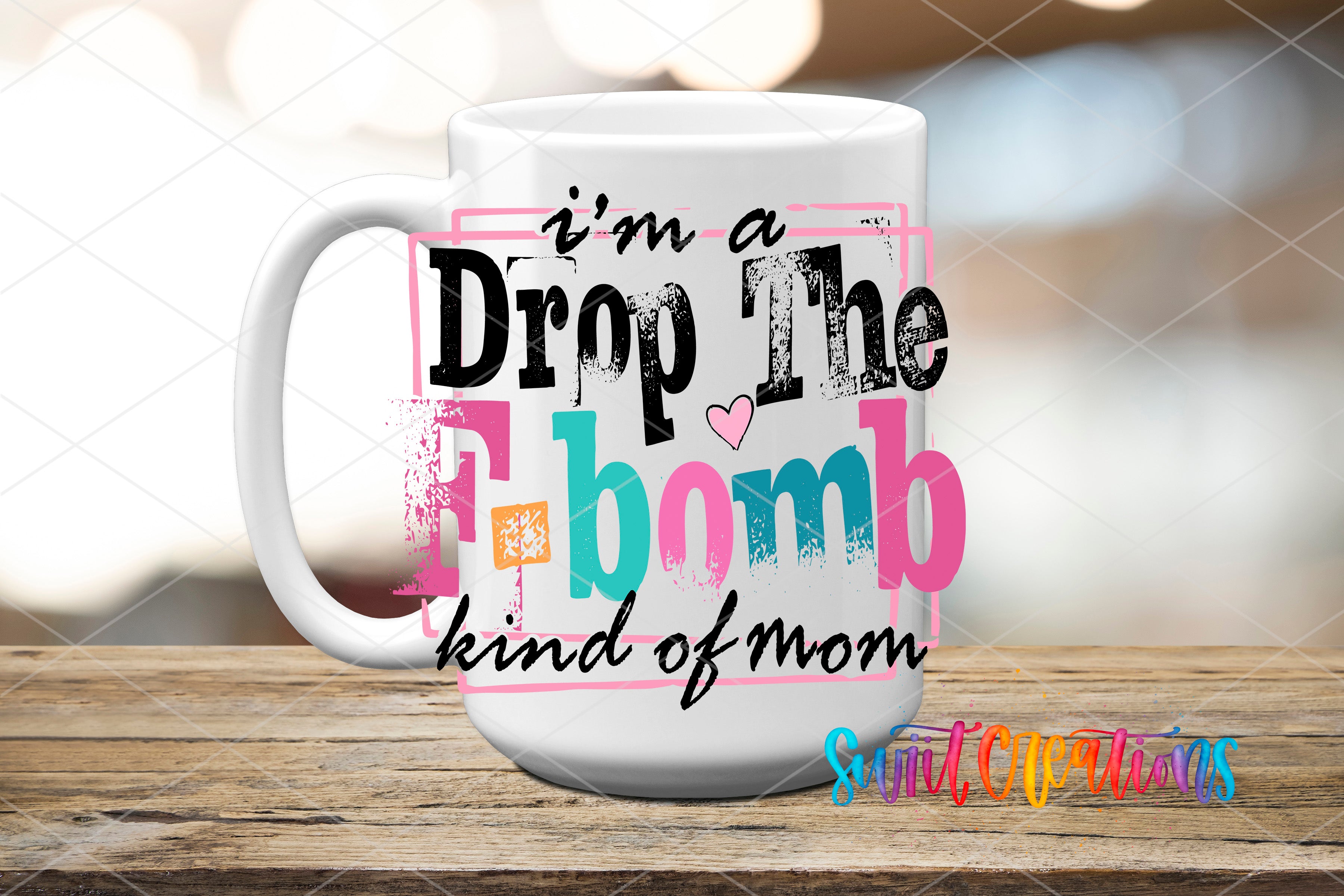 A white mug with colorful text that says "I'm a Drop The F-BOMB kind of mom" printed on it.