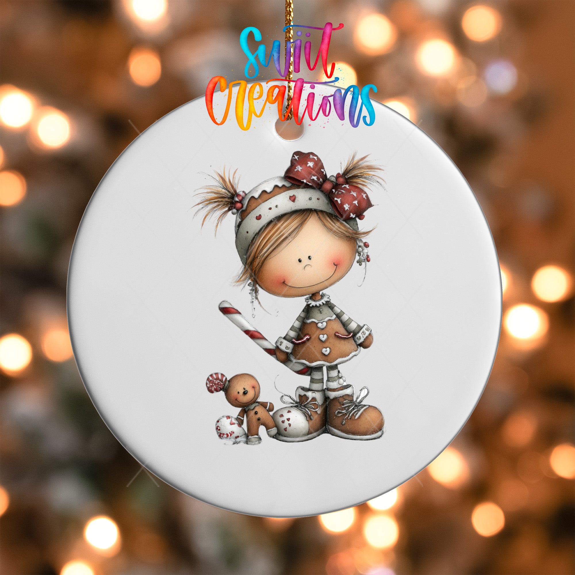 A white ornament featuring a smiling girl with a bow on her head, holding a gingerbread man, and a small teddy bear.