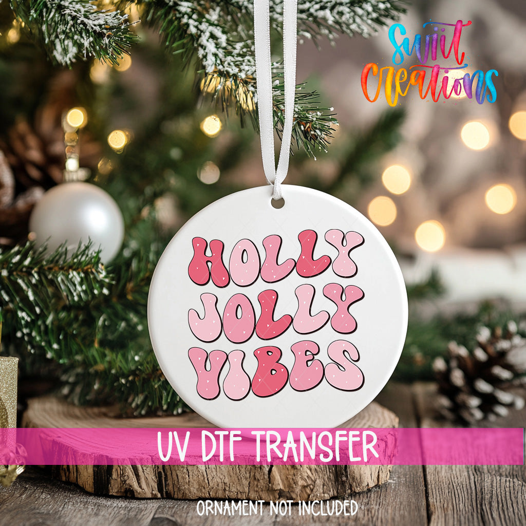 A white ornament with the text "Holly Vibes" in pink and purple letters hangs from a Christmas tree.