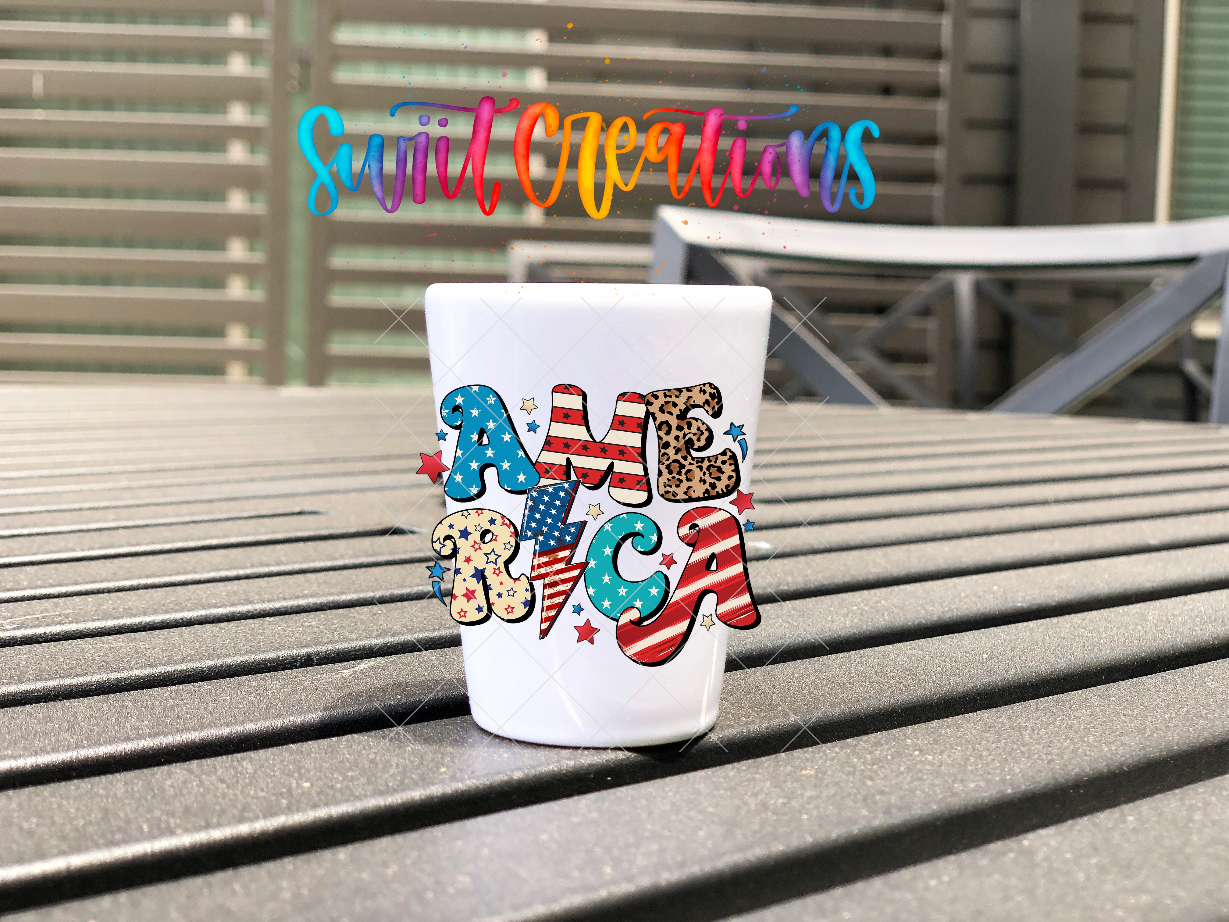 A white cup with the word "AMERICA" printed on it, sitting on a wooden surface.