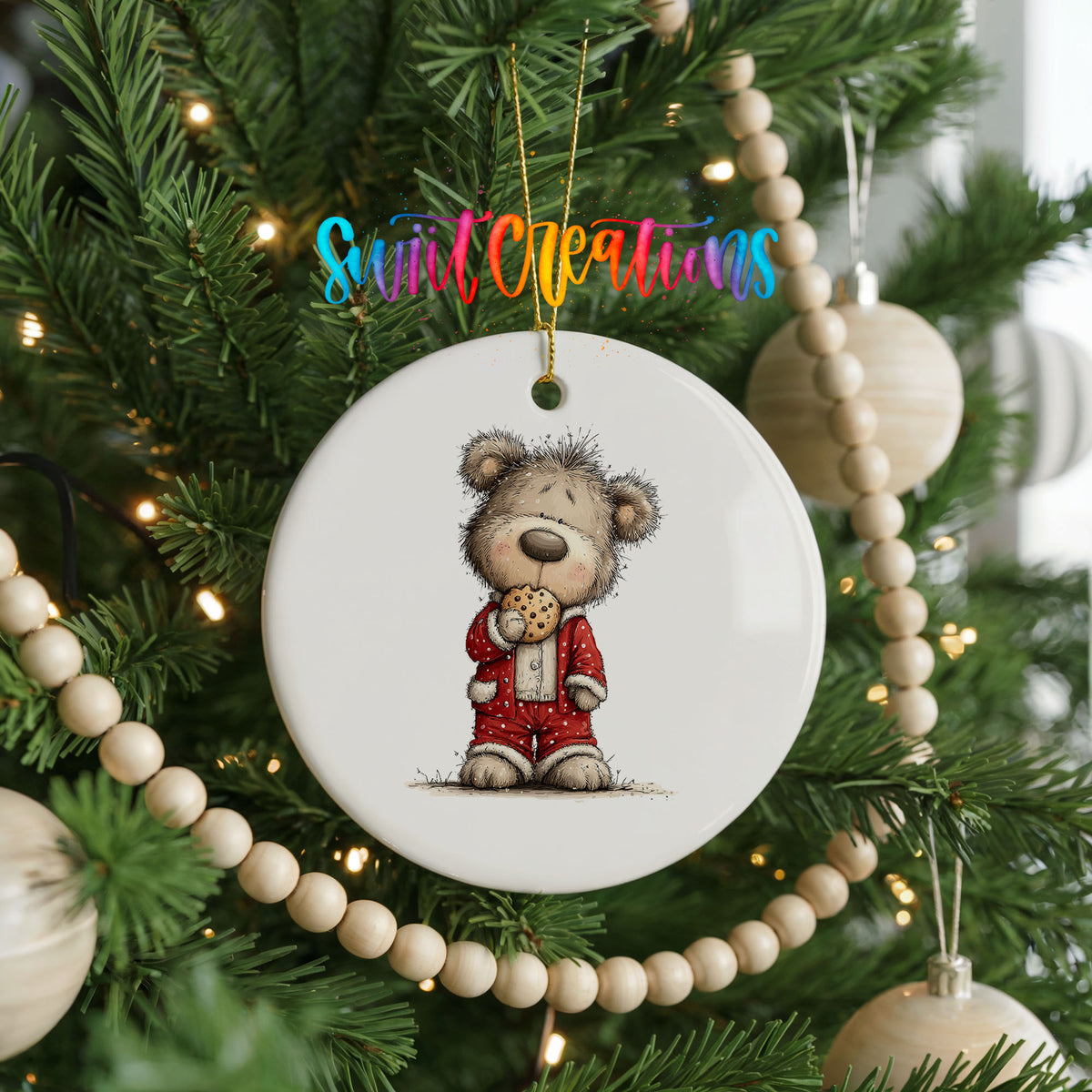 teddy bear holding a gingerbread cookie ceramic Christmas ornament hanging on a green Christmas tree