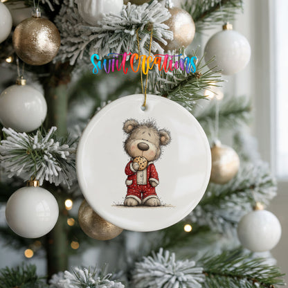 teddy bear holding a gingerbread cookie ceramic Christmas ornament hanging on a frosted tree with ornaments
