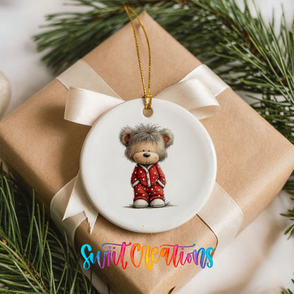teddy bear wearing red Christmas pajamas ceramic Christmas ornament displayed on a wrapped Christmas gift