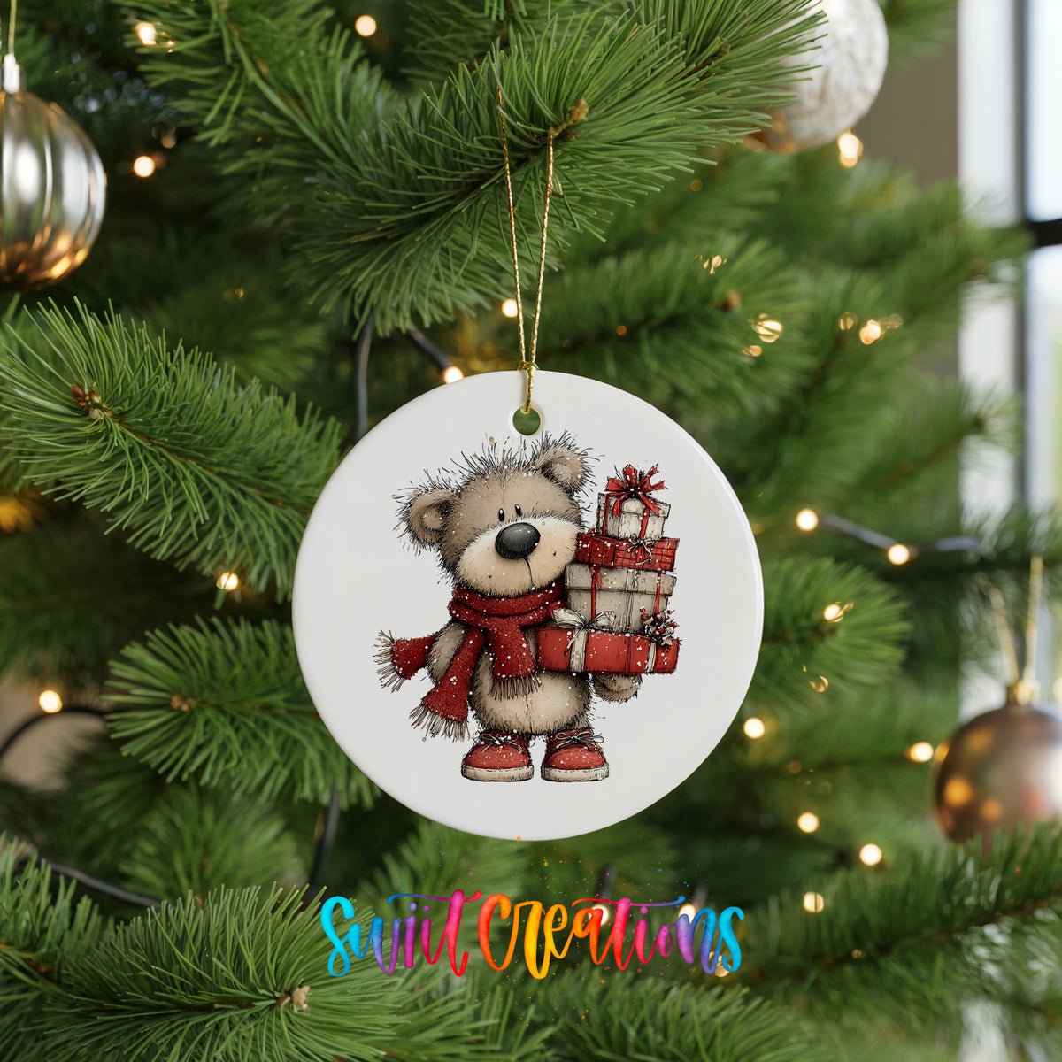teddy bear in a red scarf carrying Christmas gifts ceramic Christmas ornament hanging on a lit Christmas tree