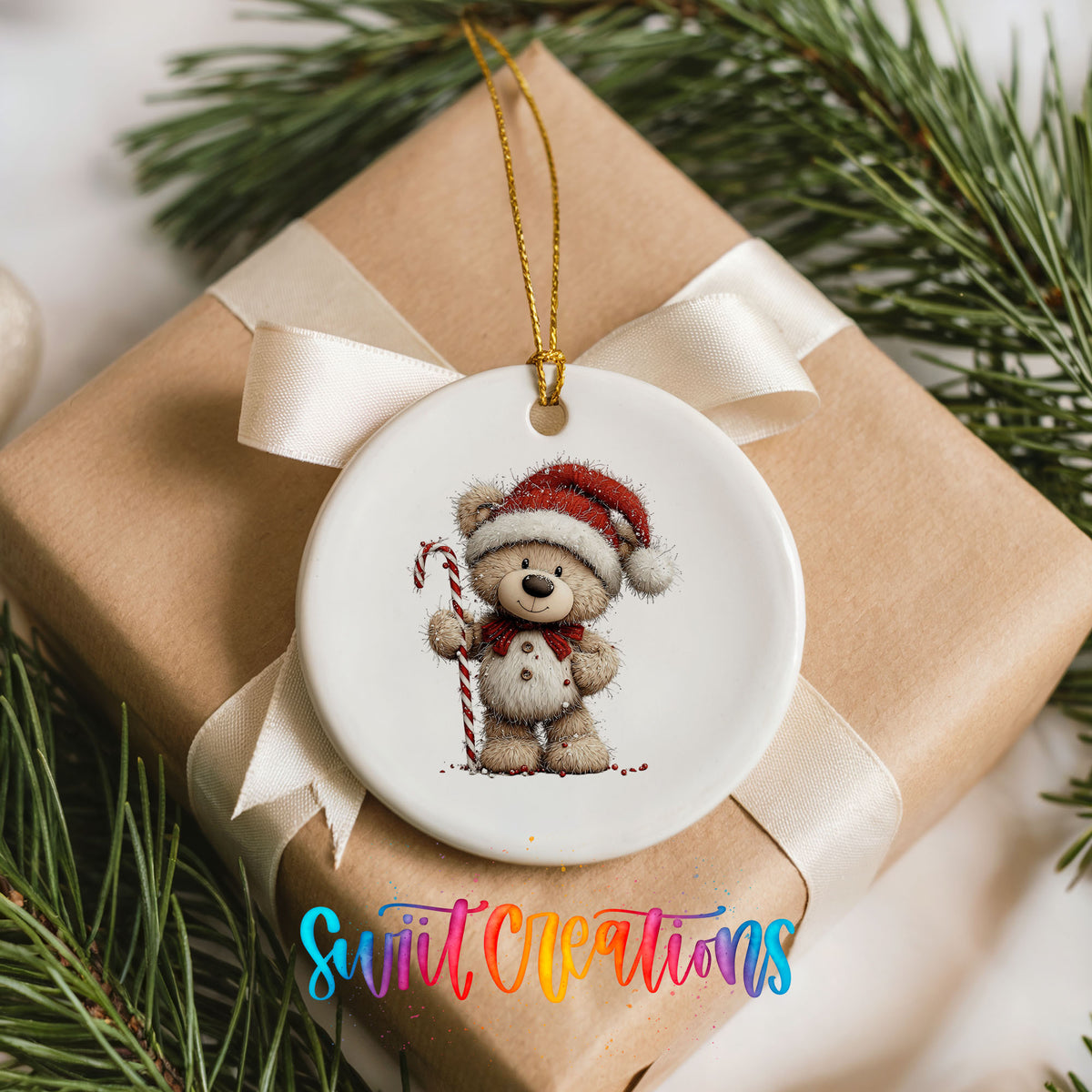 teddy bear wearing a Santa hat and holding a candy cane ceramic Christmas ornament displayed on a wrapped Christmas gift