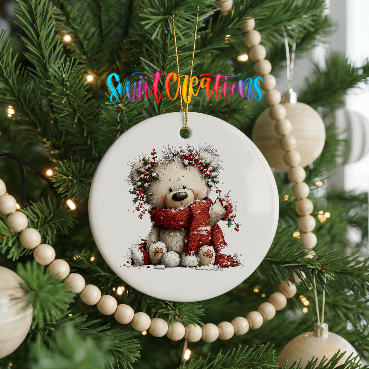 teddy bear with a red scarf and winter greenery ceramic Christmas ornament hanging on a green Christmas tree