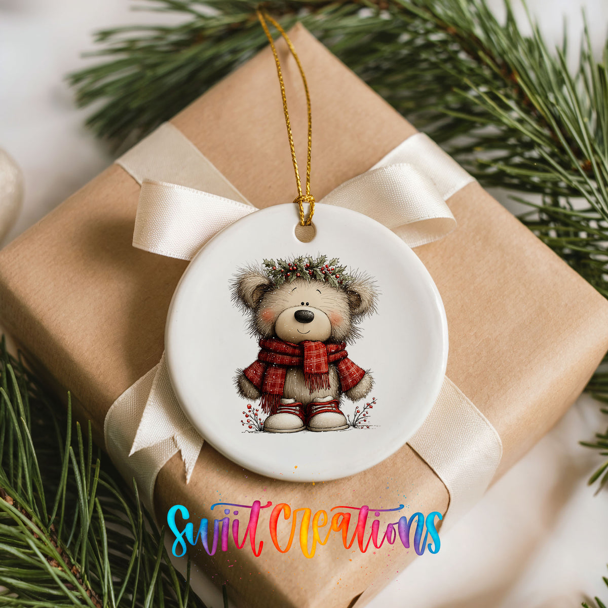 teddy bear in a red plaid scarf with holly ceramic Christmas ornament displayed on a wrapped Christmas gift