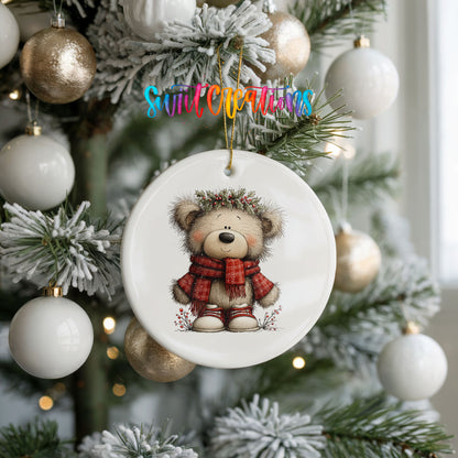 teddy bear in a red plaid scarf with holly ceramic Christmas ornament hanging on a frosted tree with ornaments