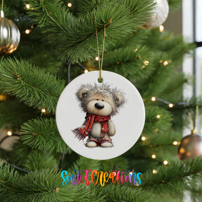 teddy bear in a red scarf standing in the snow ceramic Christmas ornament hanging on a lit Christmas tree