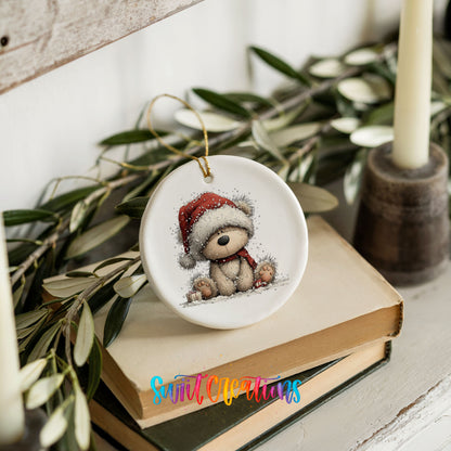 seated teddy bear in a red Santa hat ceramic Christmas ornament styled on stacked books with greenery