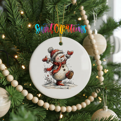 playful snowman in a red scarf ceramic Christmas ornament hanging on a green Christmas tree