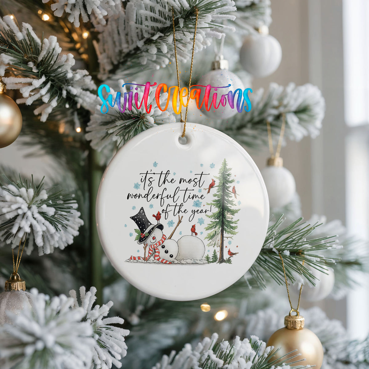 It's the Most Wonderful Time of the Year snowman design ceramic Christmas ornament hanging on a frosted Christmas tree