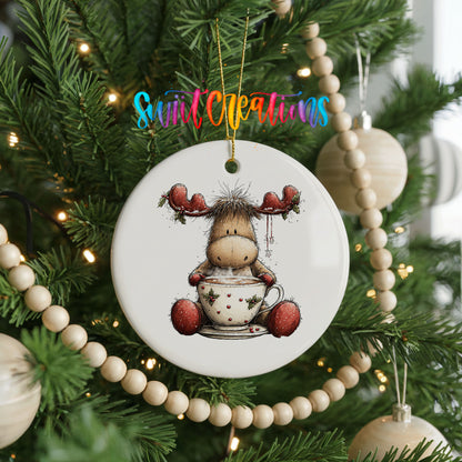 woodland moose in a snowman sweater ceramic Christmas ornament hanging on a green Christmas tree