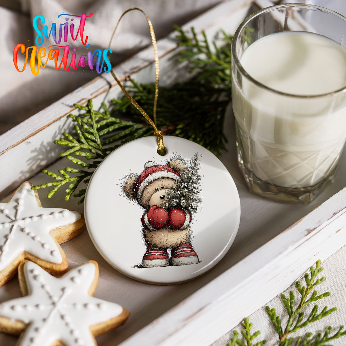 woodland bear in a Santa hat carrying a Christmas tree ceramic Christmas ornament styled with holiday cookies and a candle