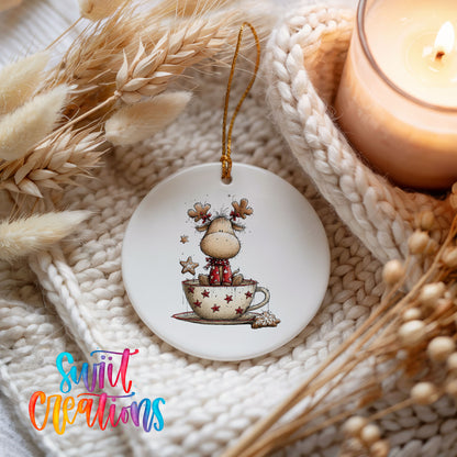 woodland reindeer sitting in a holiday teacup ceramic Christmas ornament styled on a cozy knit blanket